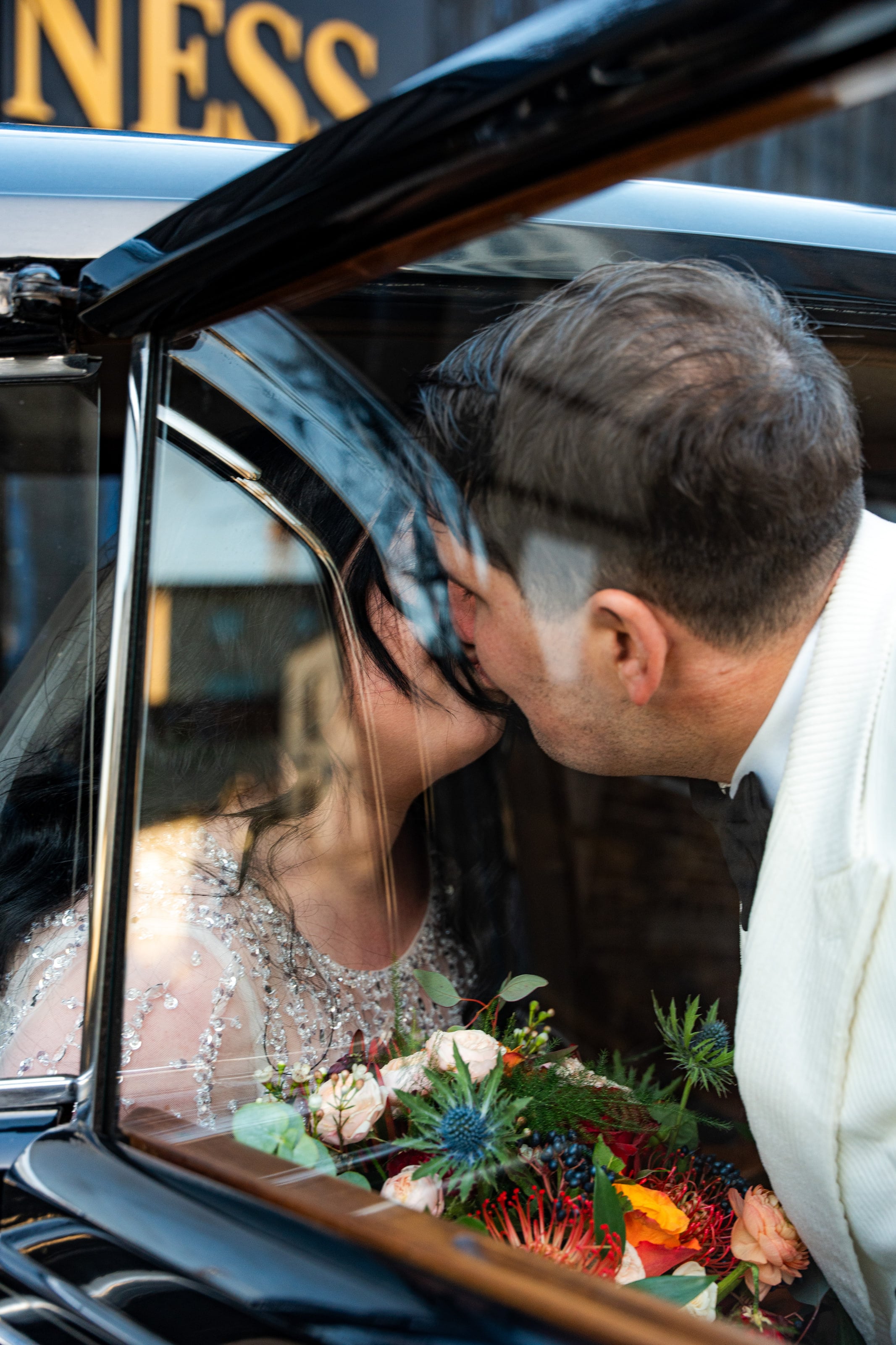 Beijo pela janela do carro antigo, buquê no colo, casamento de C & S