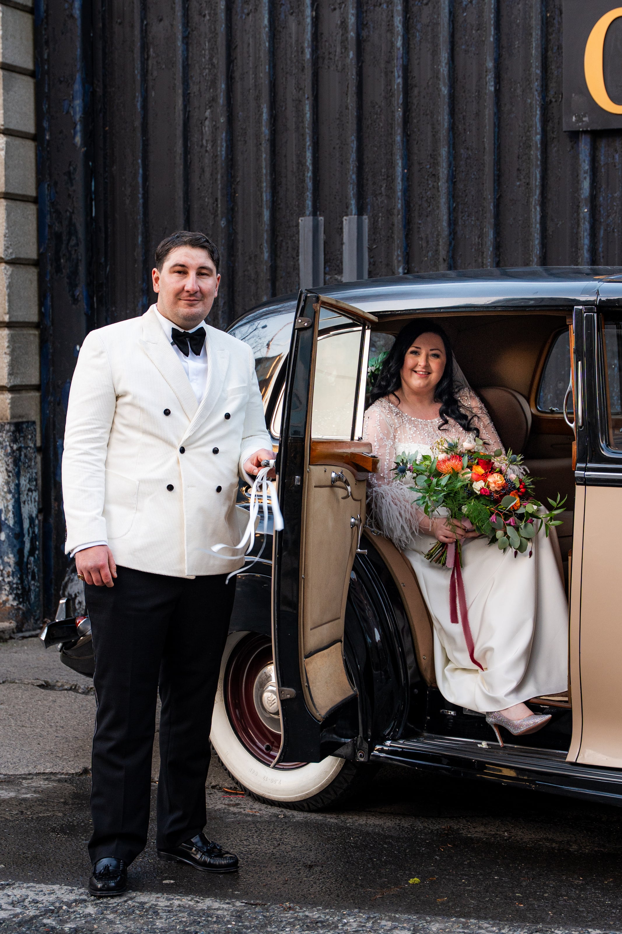 Noivo segura a porta do carro antigo para a noiva, casamento de C & S