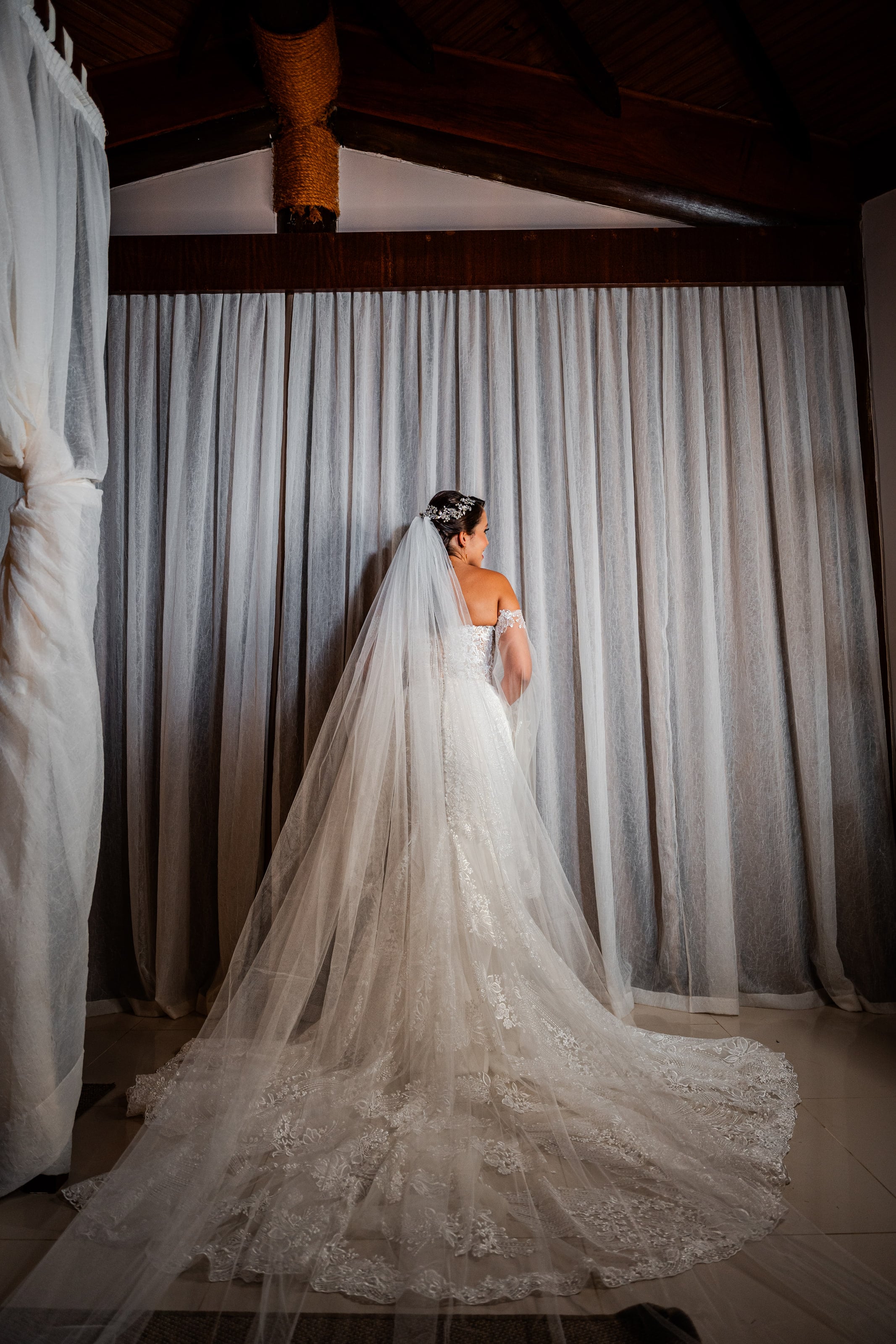 Noiva de costas mostrando a cauda longa do véu, casamento de D & S