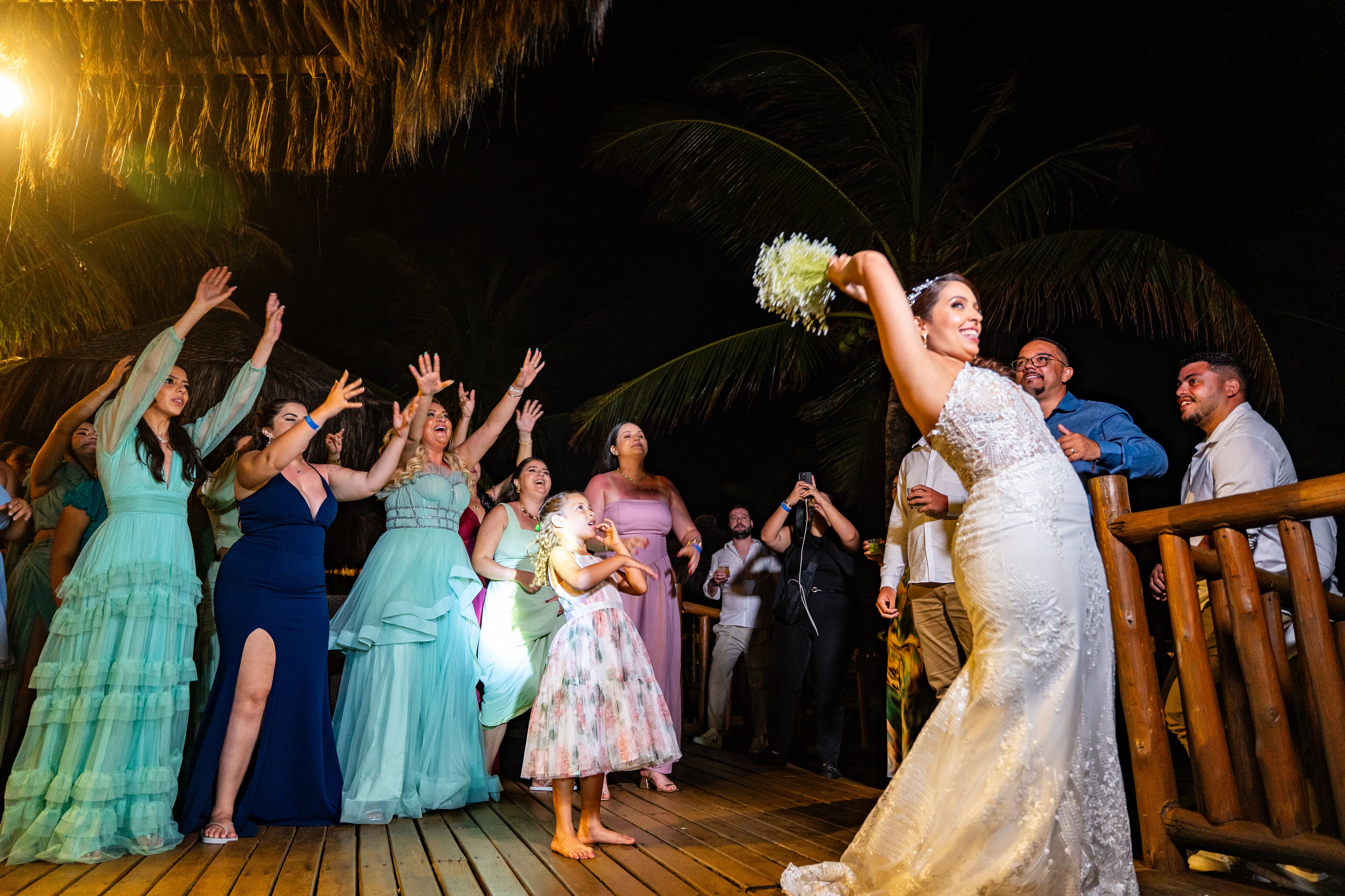 Noiva joga o buquê para as convidadas à noite, casamento de D & S