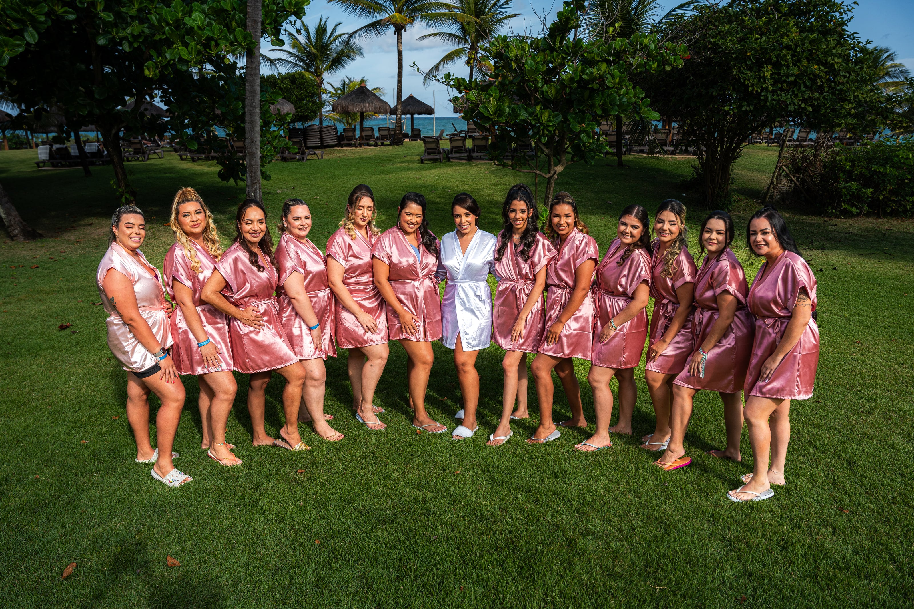 Noiva com as madrinhas de robe rosa no gramado, casamento de D & S