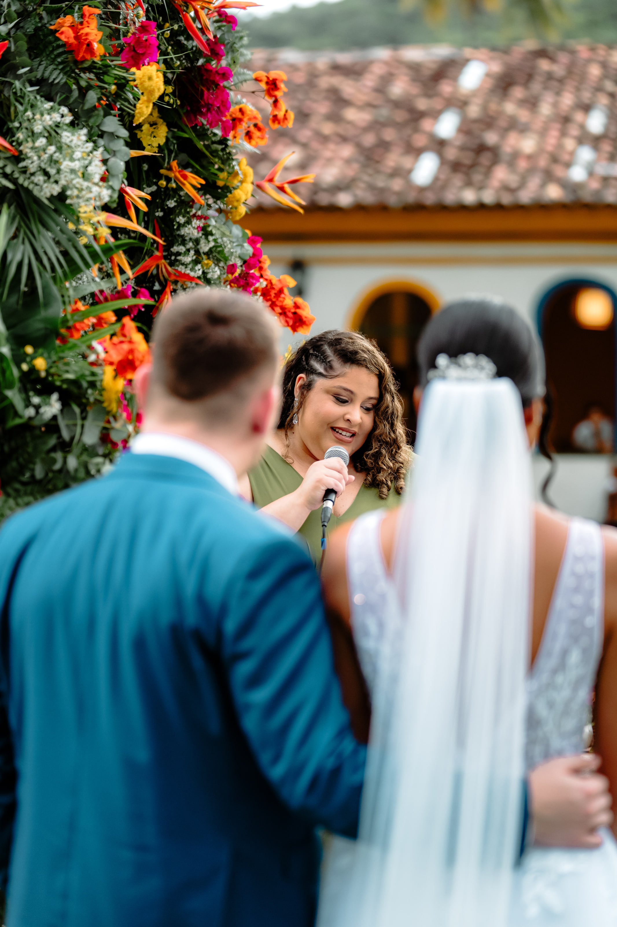 Celebrante fala ao microfone diante do casal, casamento de J & K