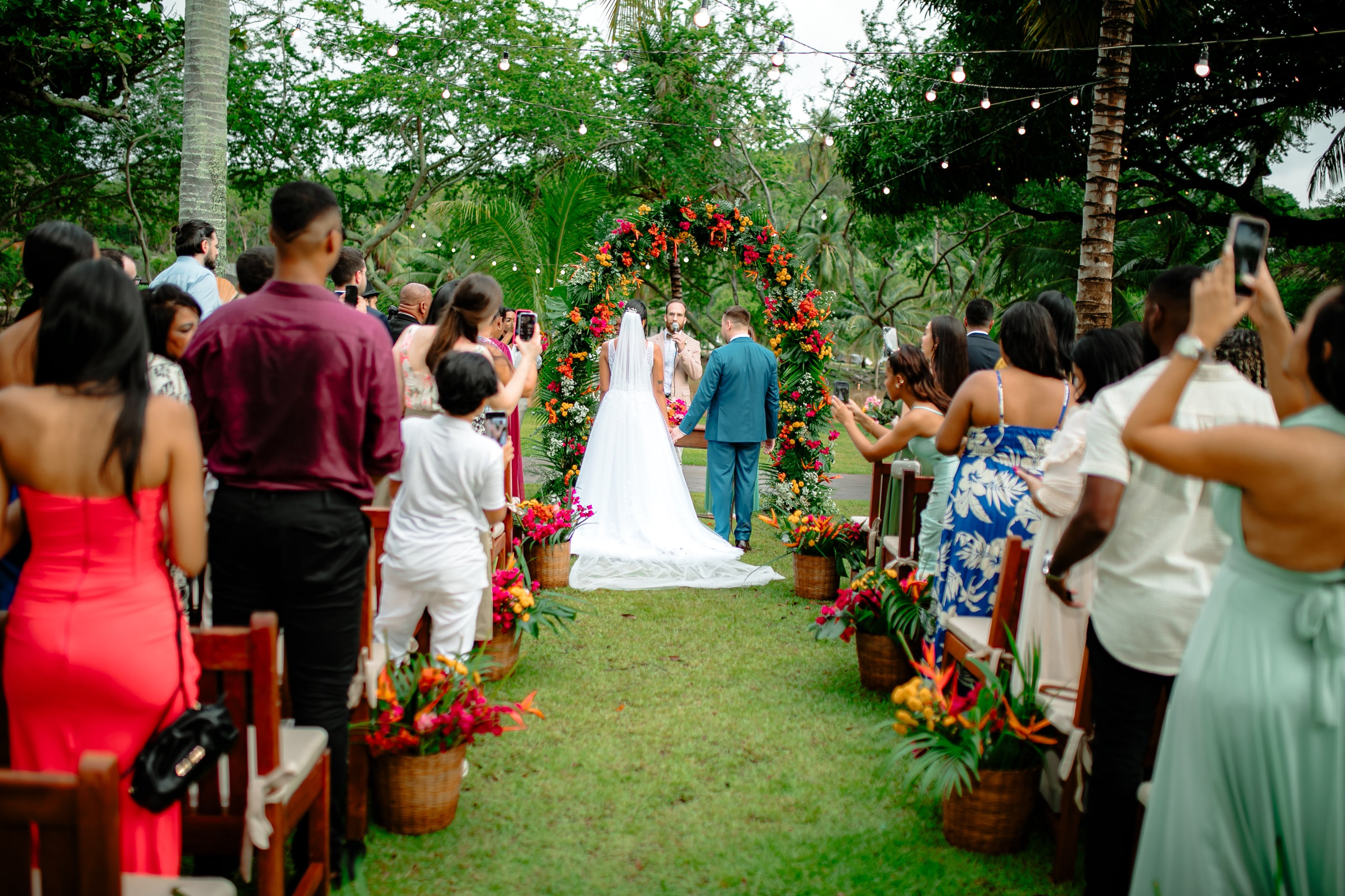 Entrada da noiva pelo corredor de grama, entre convidados, casamento de J & K