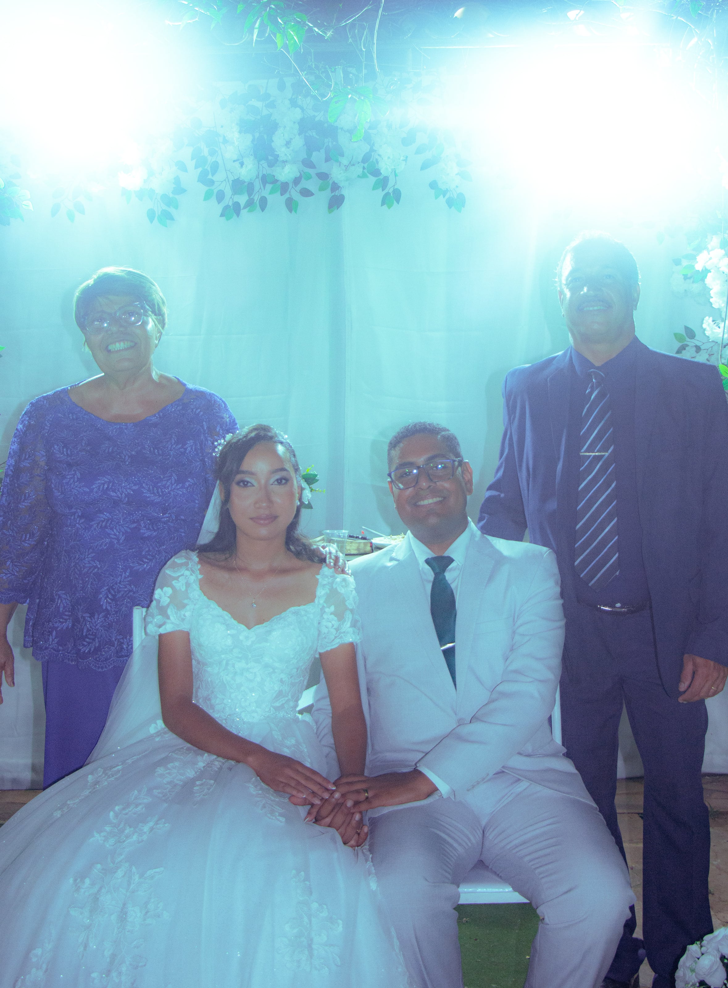 Casal com familiares diante da cortina branca, casamento de M & I