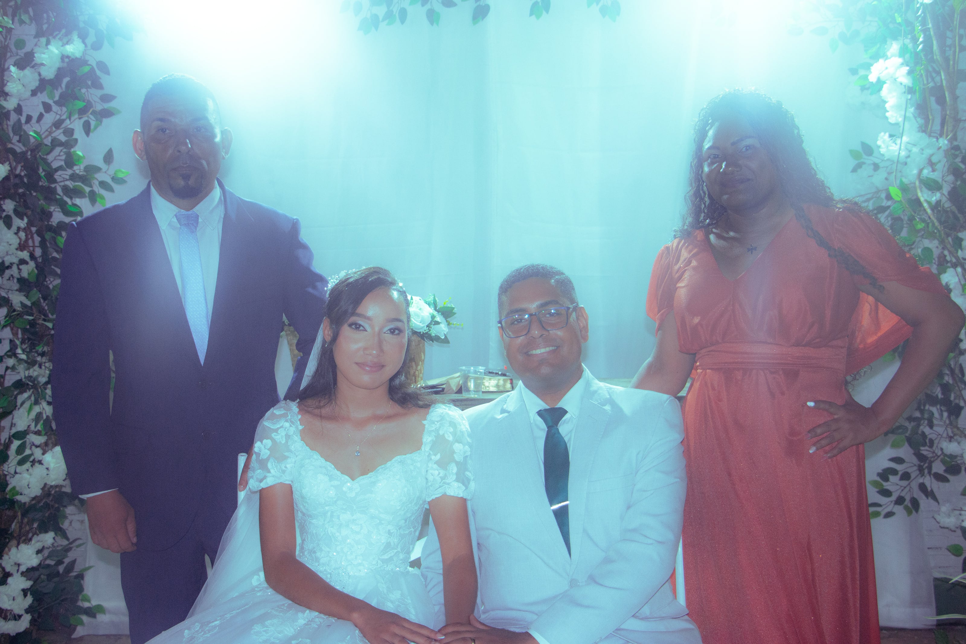 Casal com familiares diante da cortina branca, casamento de M & I
