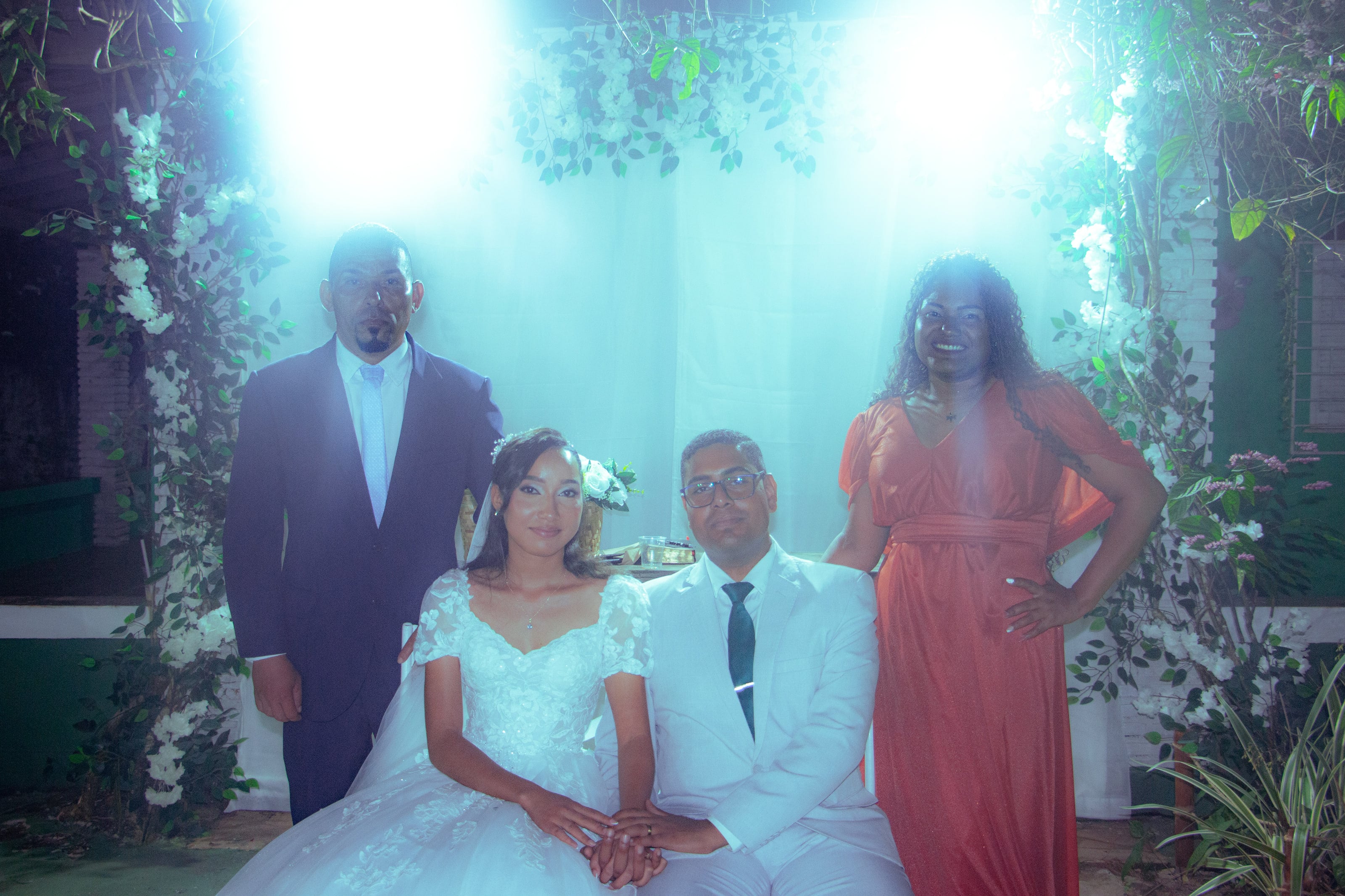 Casal com familiares diante da cortina branca, casamento de M & I