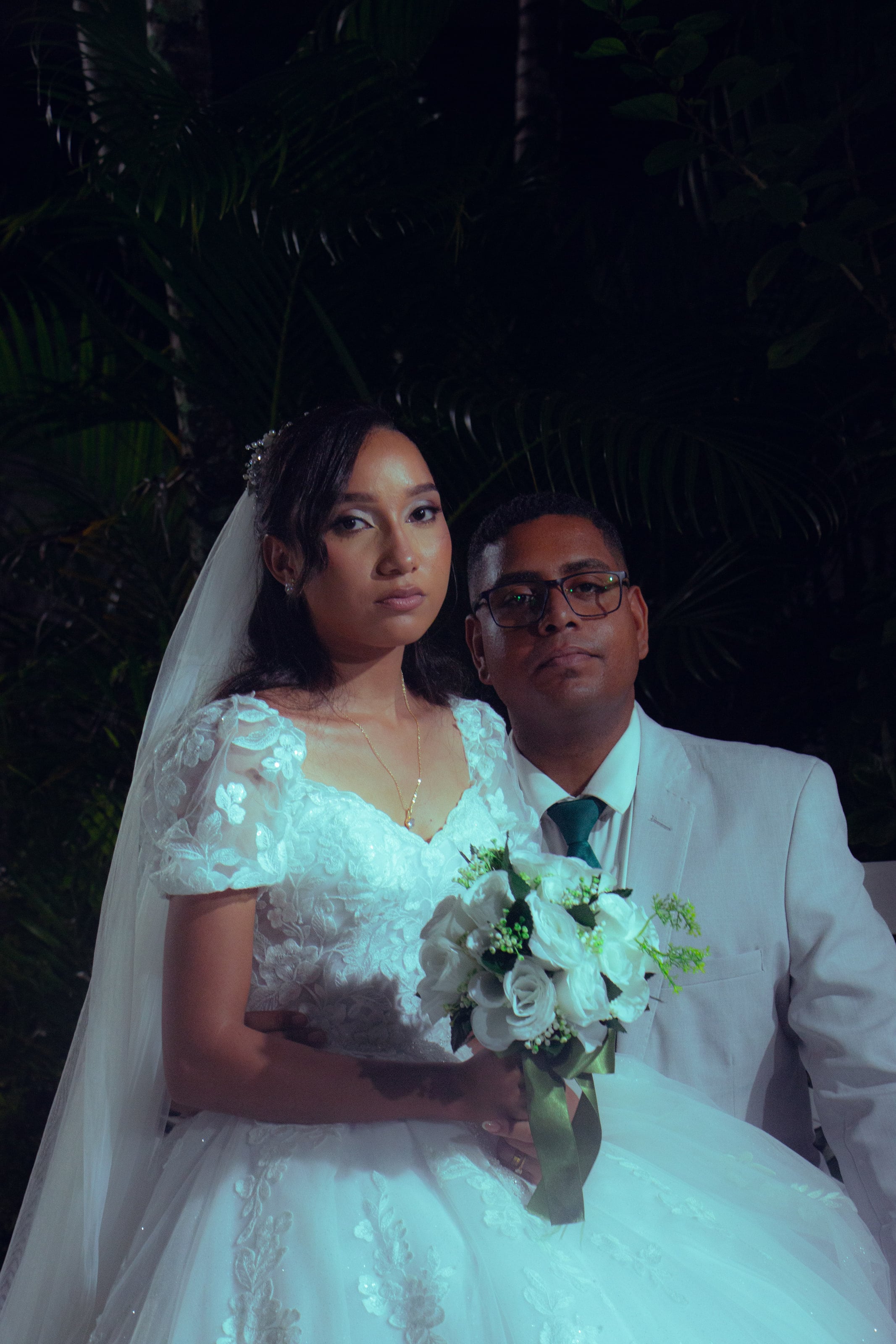 Retrato do casal sentado com o buquê de flores brancas, casamento de M & I