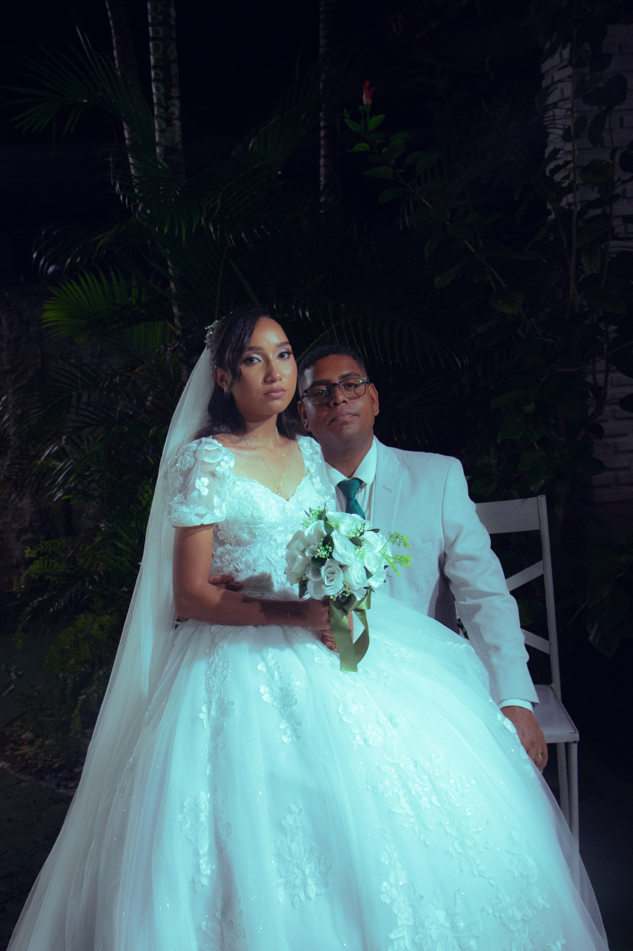Retrato do casal sentado com o buquê de flores brancas, casamento de M & I
