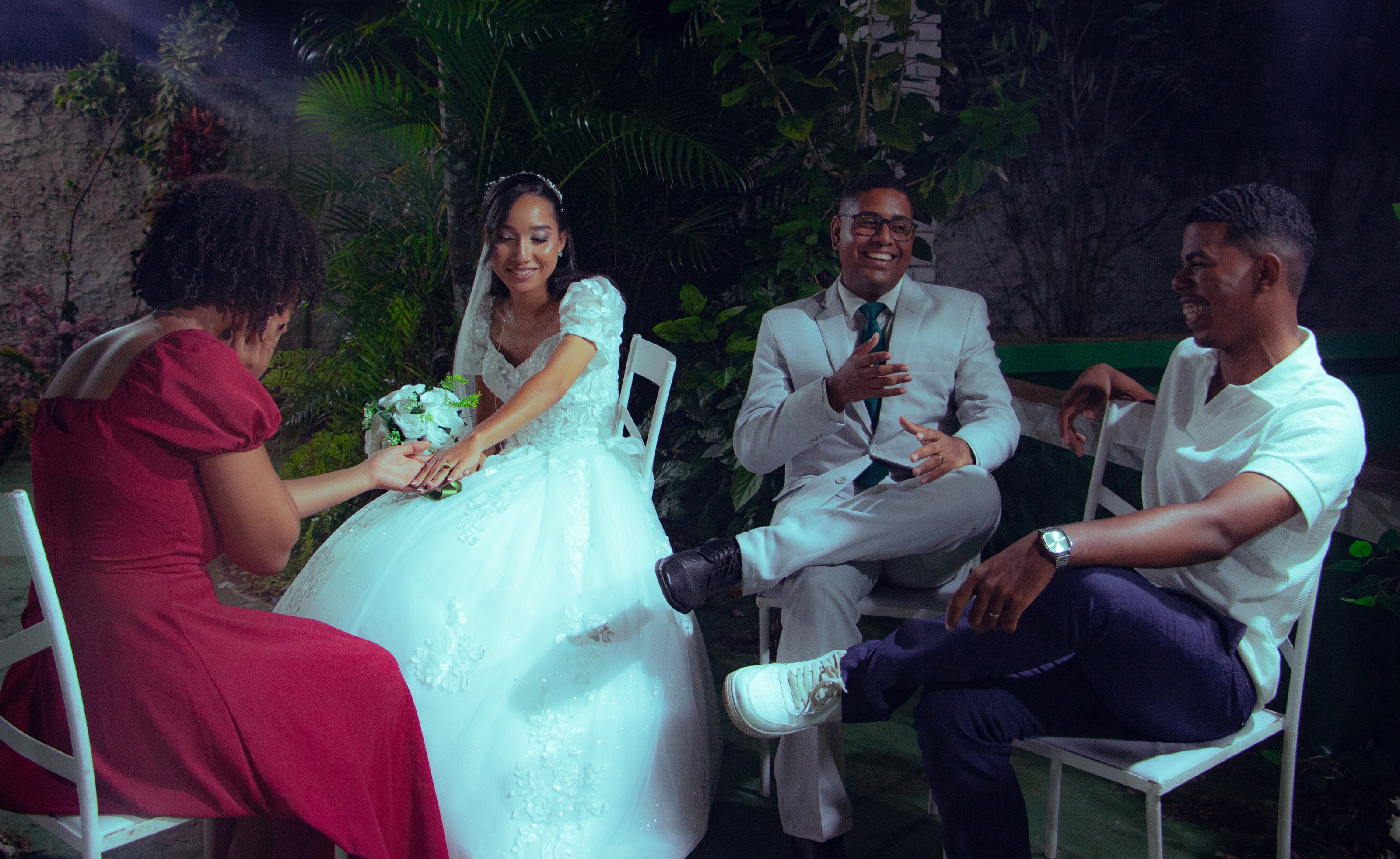 Casal conversando com convidados nas cadeiras do jardim, casamento de M & I