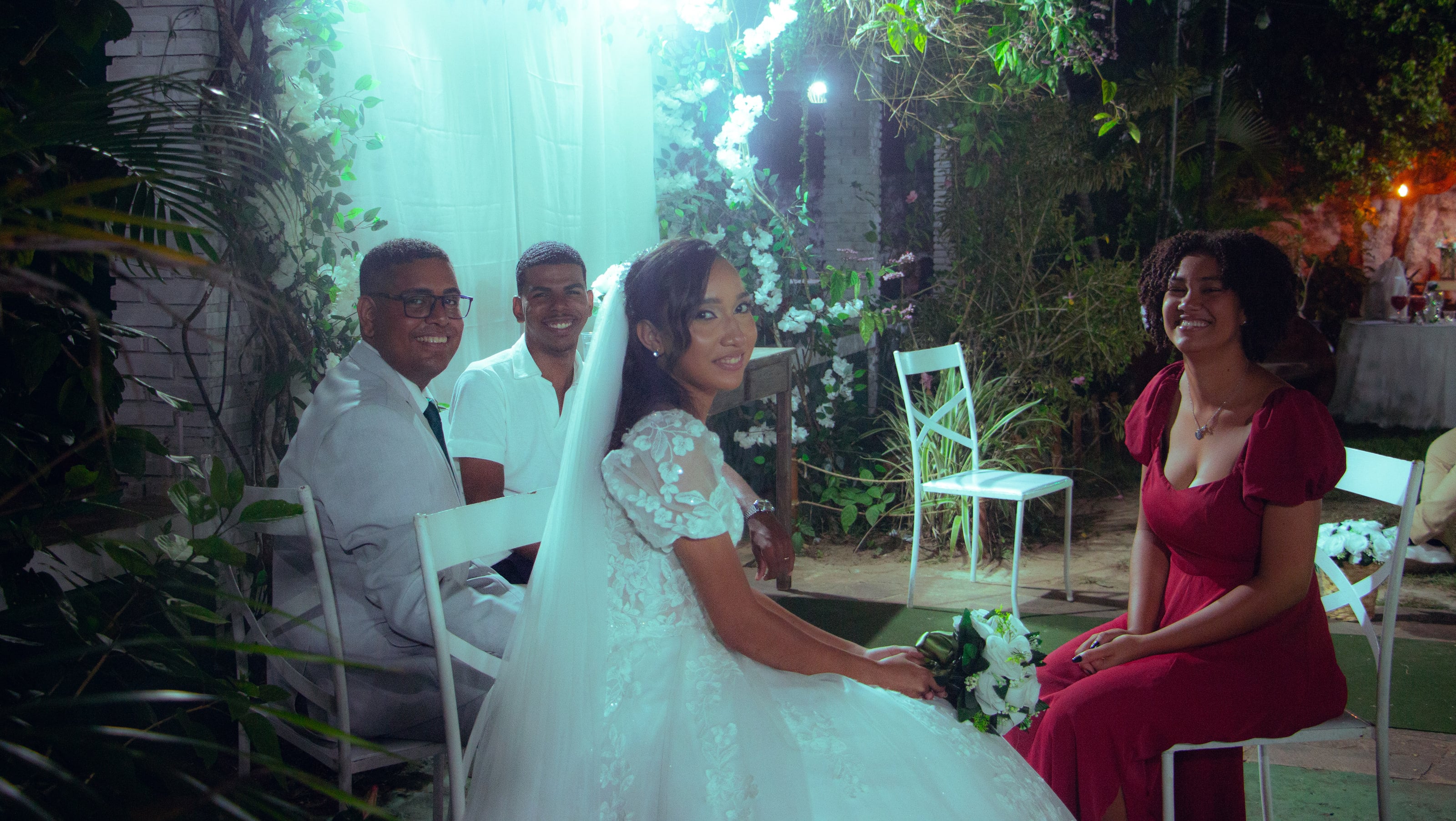 Casal conversando com convidados nas cadeiras do jardim, casamento de M & I