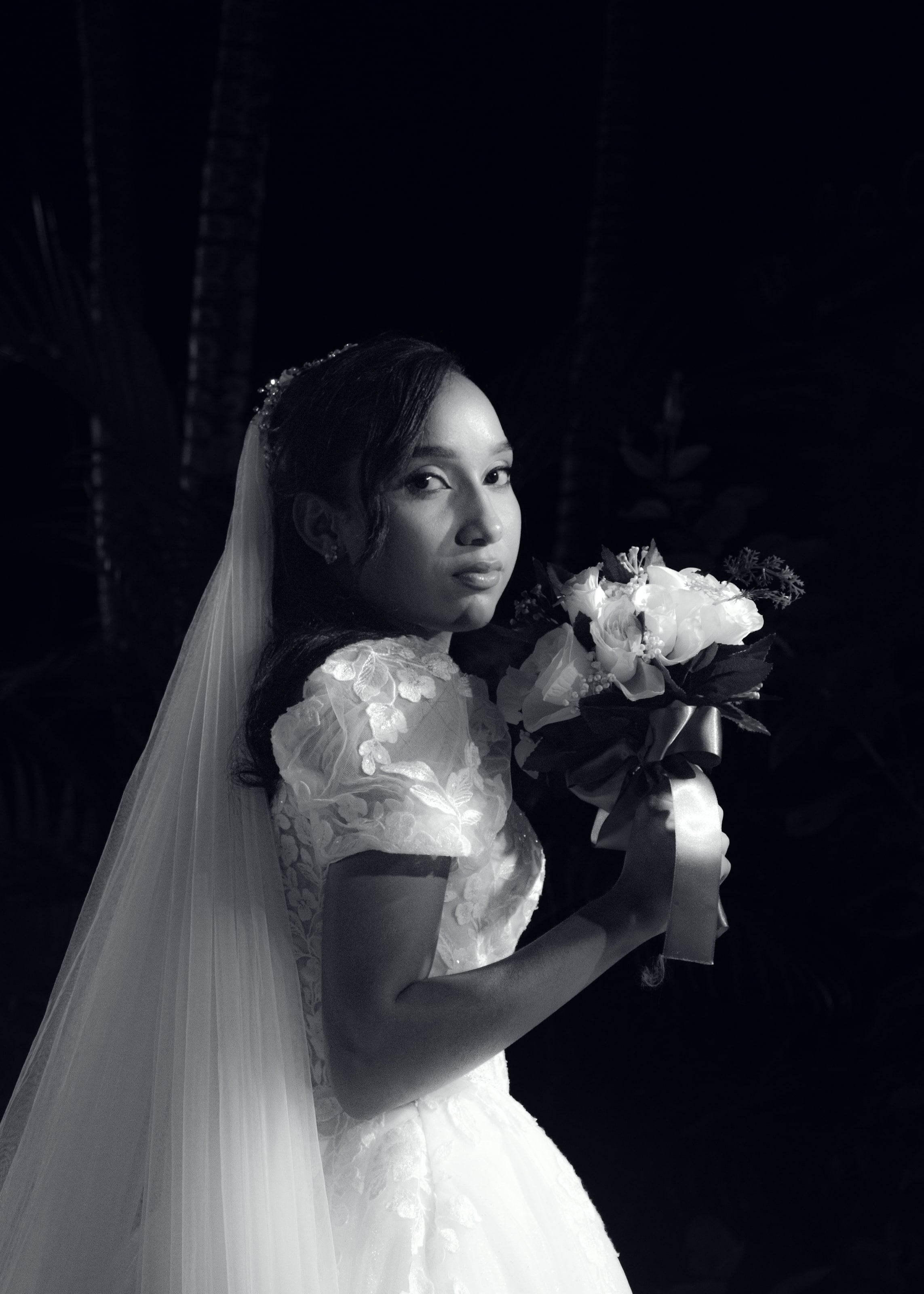 Noiva com o véu longo e o buquê no jardim à noite, casamento de M & I