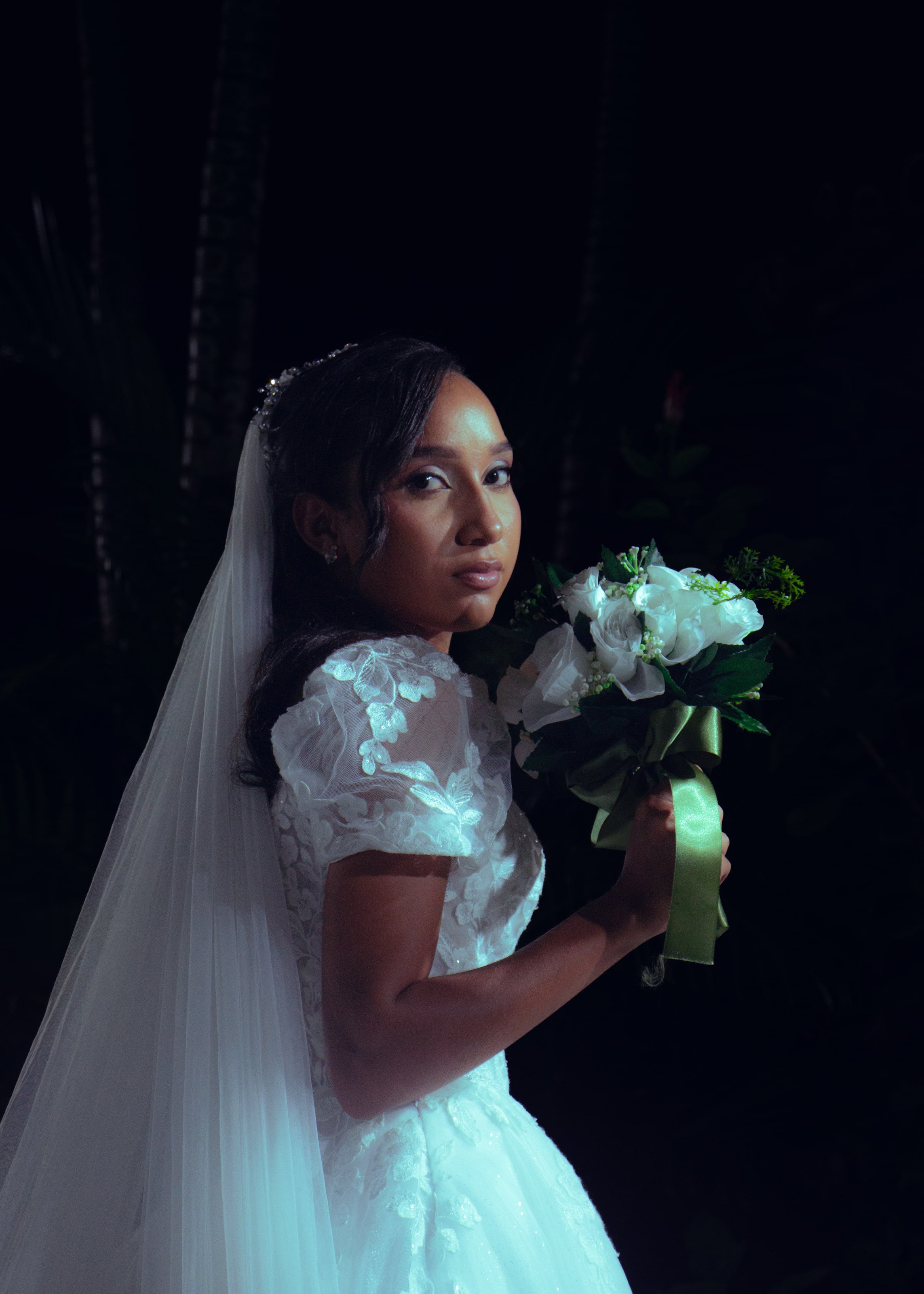 Noiva com o véu longo e o buquê no jardim à noite, casamento de M & I