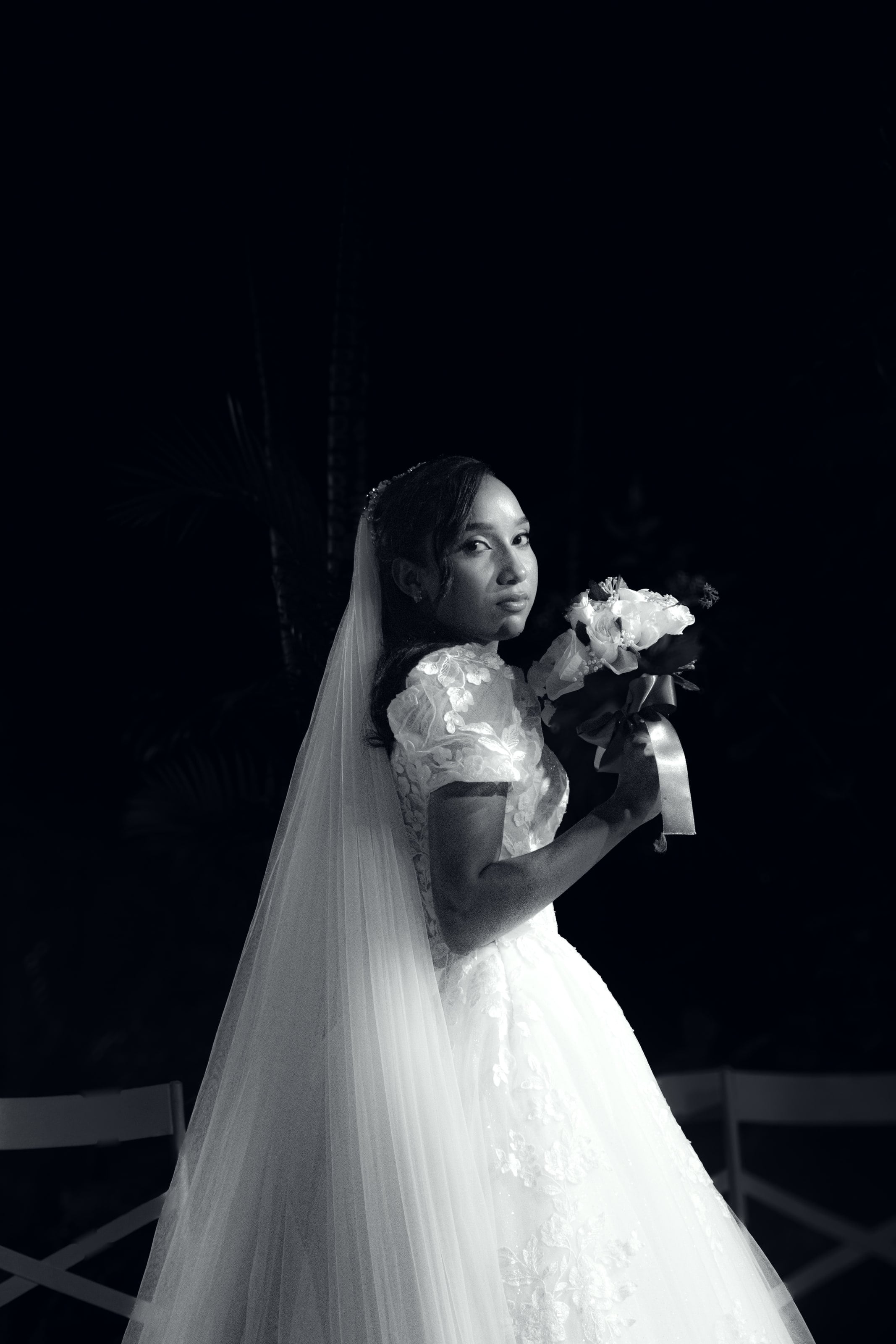 Noiva com o véu longo e o buquê no jardim à noite, casamento de M & I