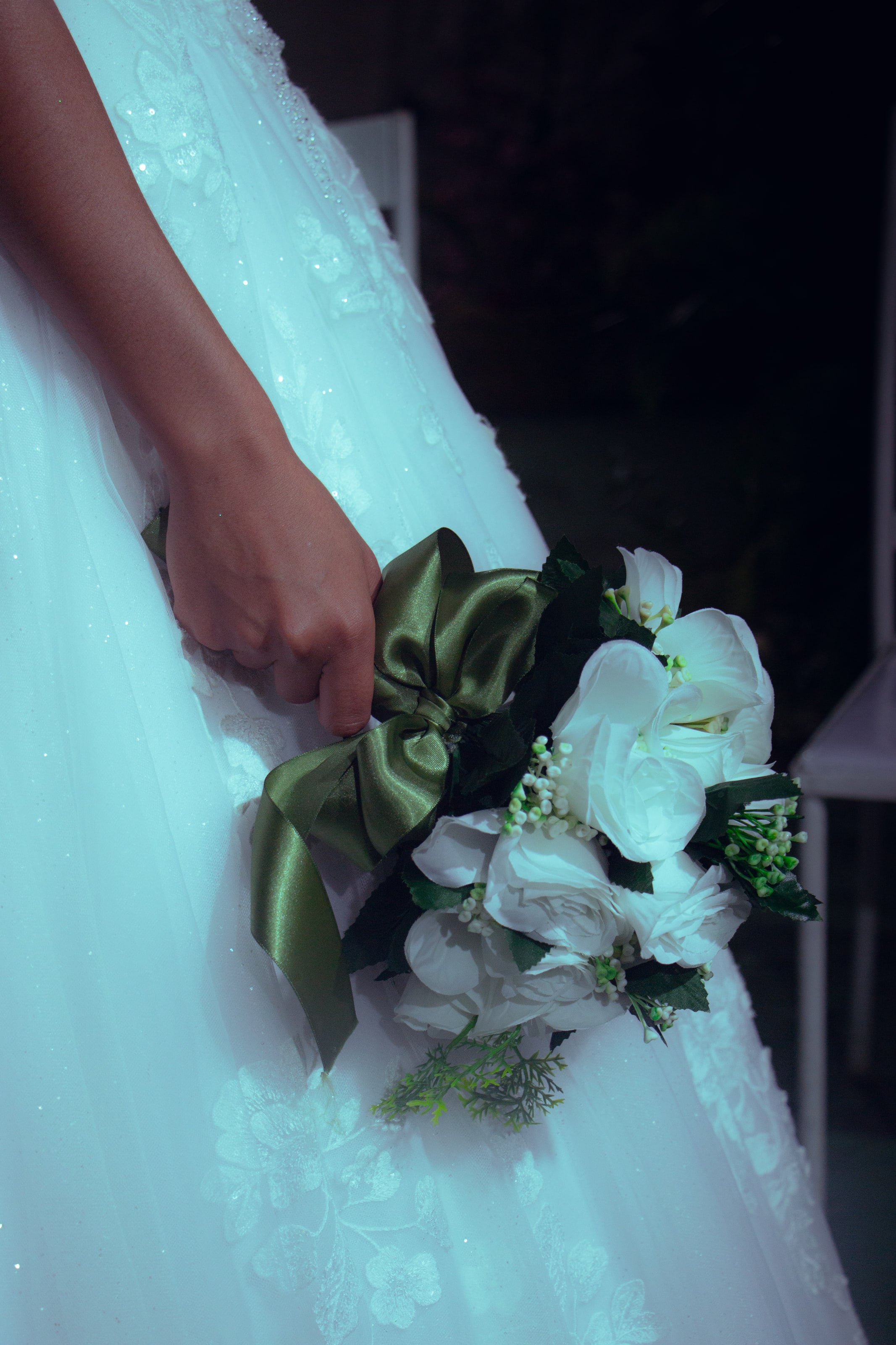 Buquê de flores brancas com fita verde junto ao vestido, casamento de M & I