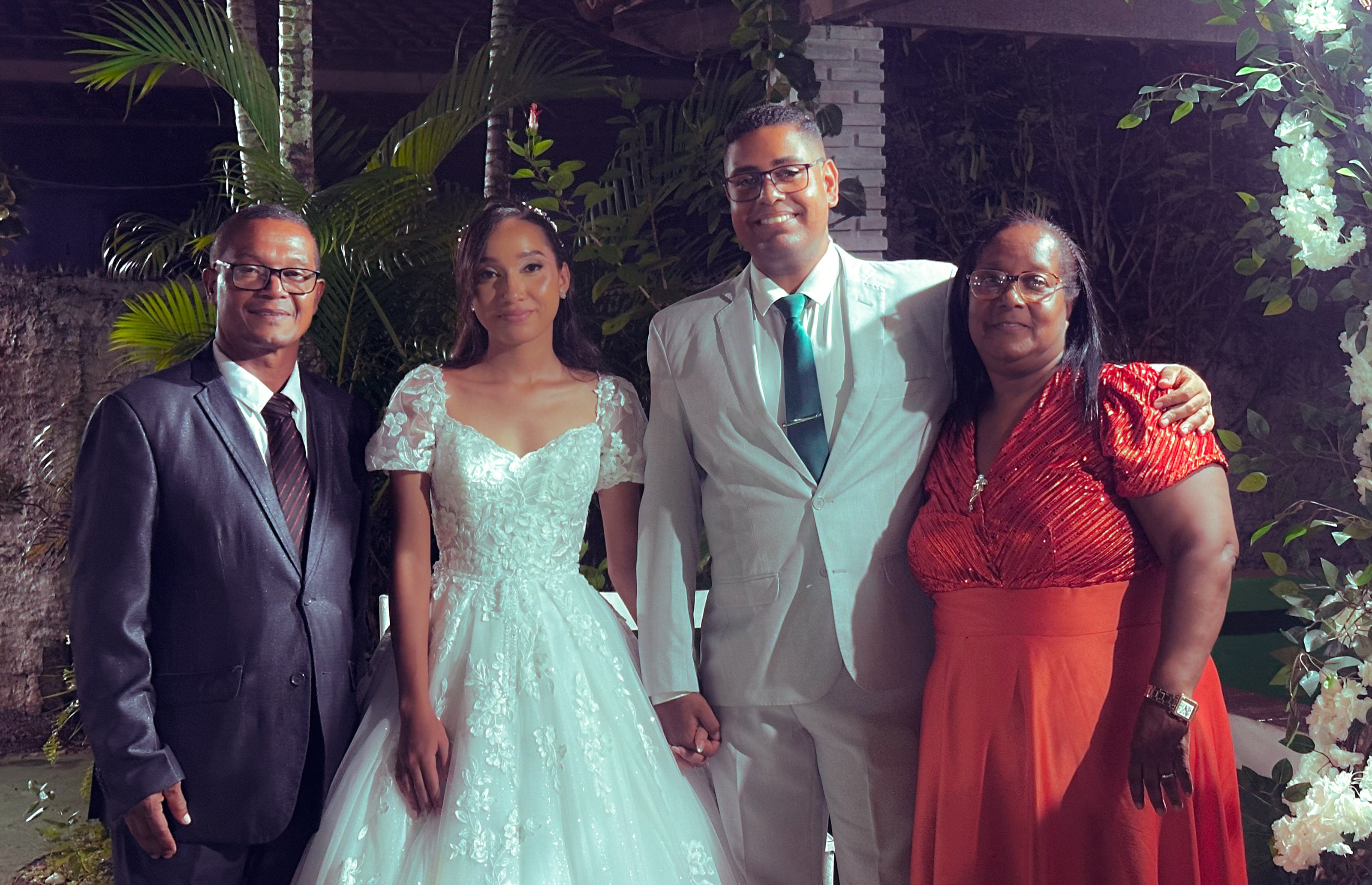 Noiva e noivo com familiares no jardim, à noite, casamento de M & I