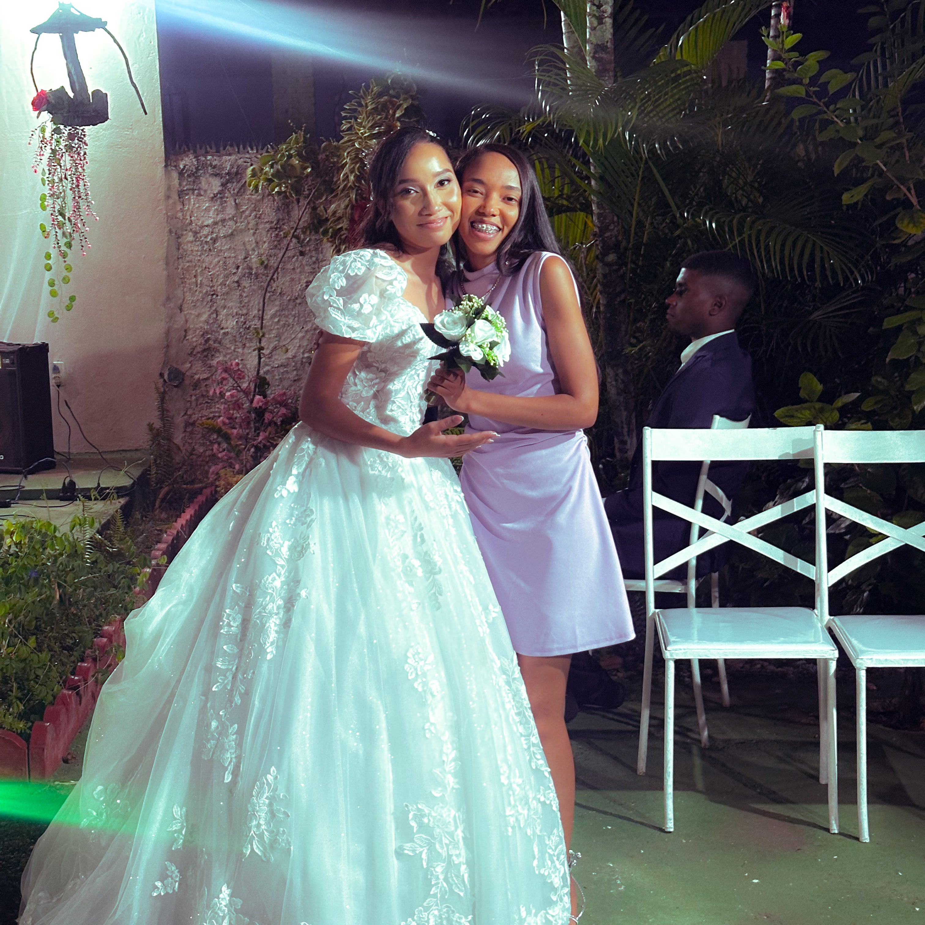 Noiva e noivo com familiares no jardim, à noite, casamento de M & I