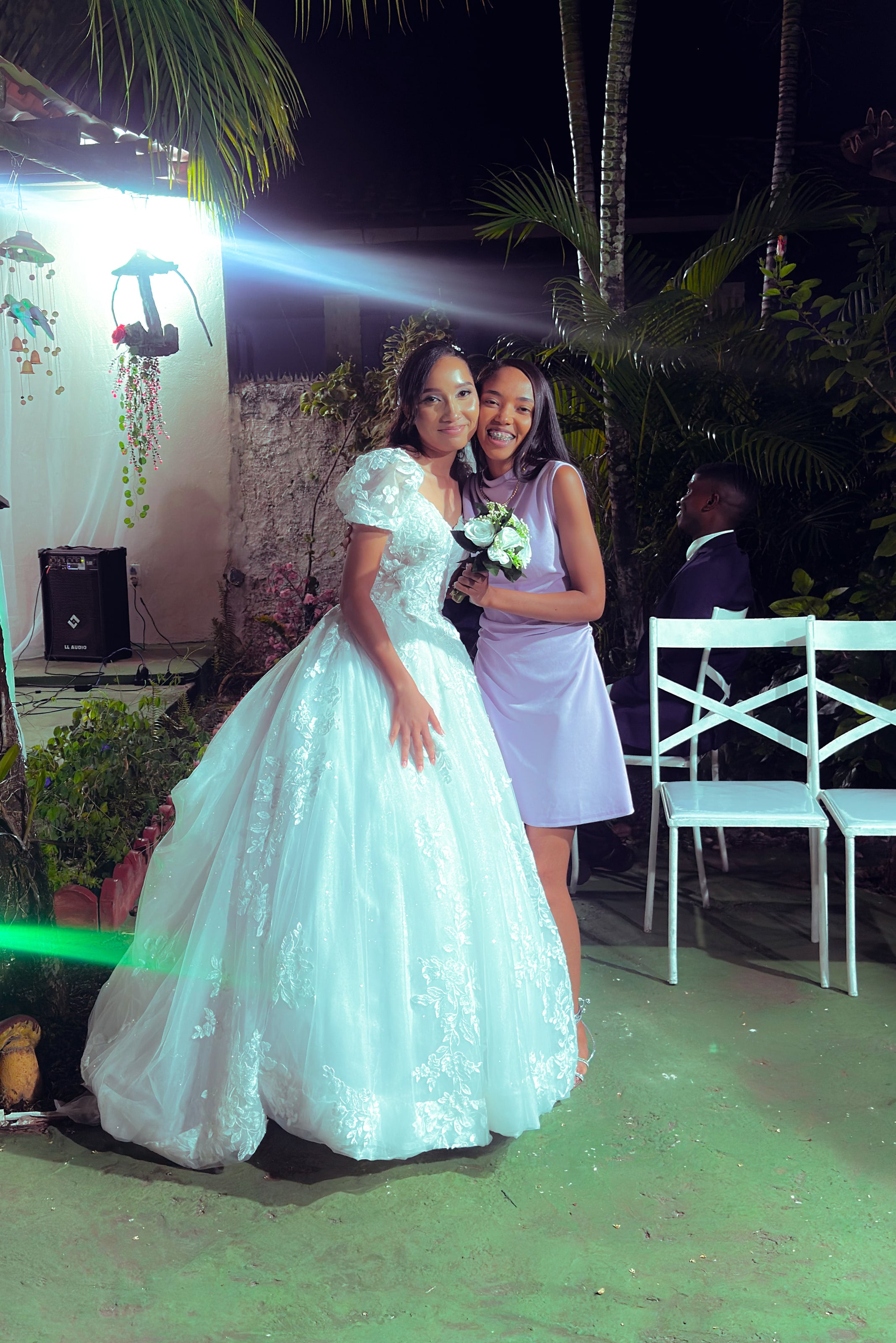 Noiva e noivo com familiares no jardim, à noite, casamento de M & I