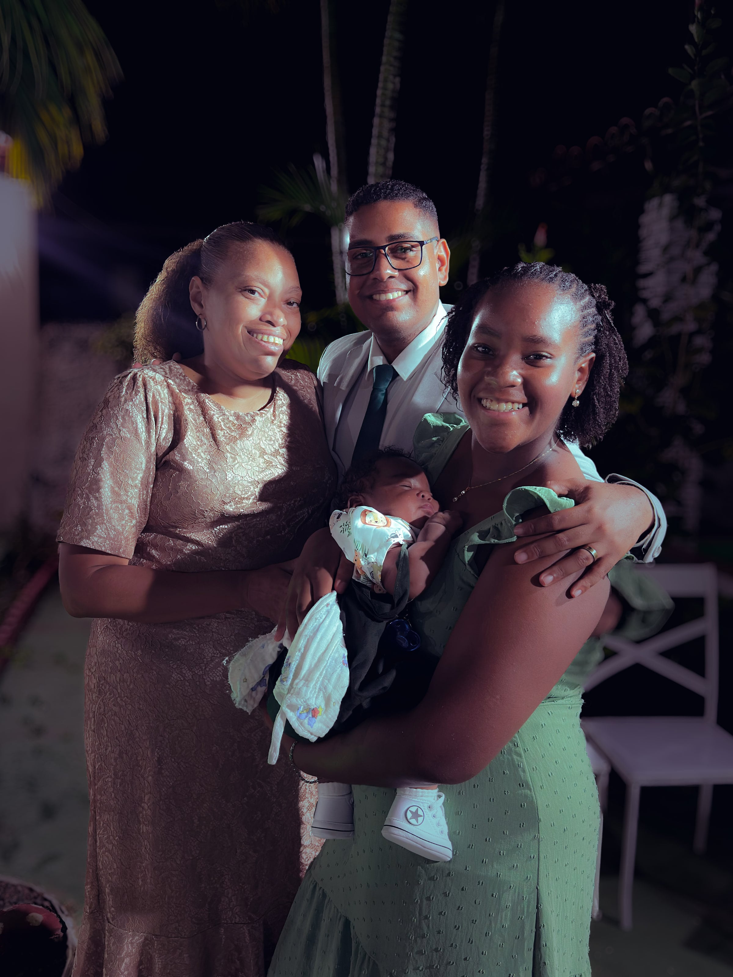 Noiva e noivo com convidados no jardim, à noite, casamento de M & I