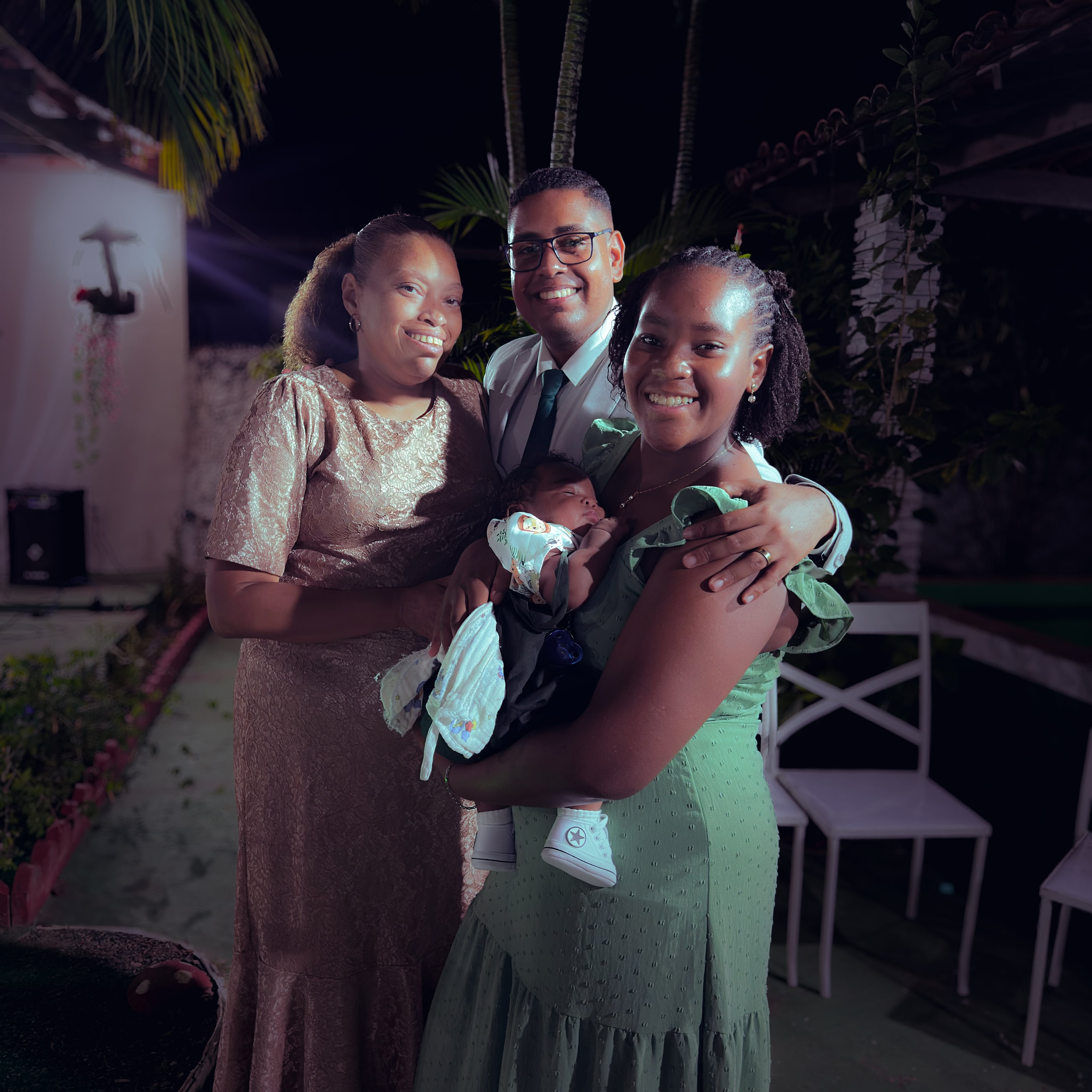 Noiva e noivo com convidados no jardim, à noite, casamento de M & I