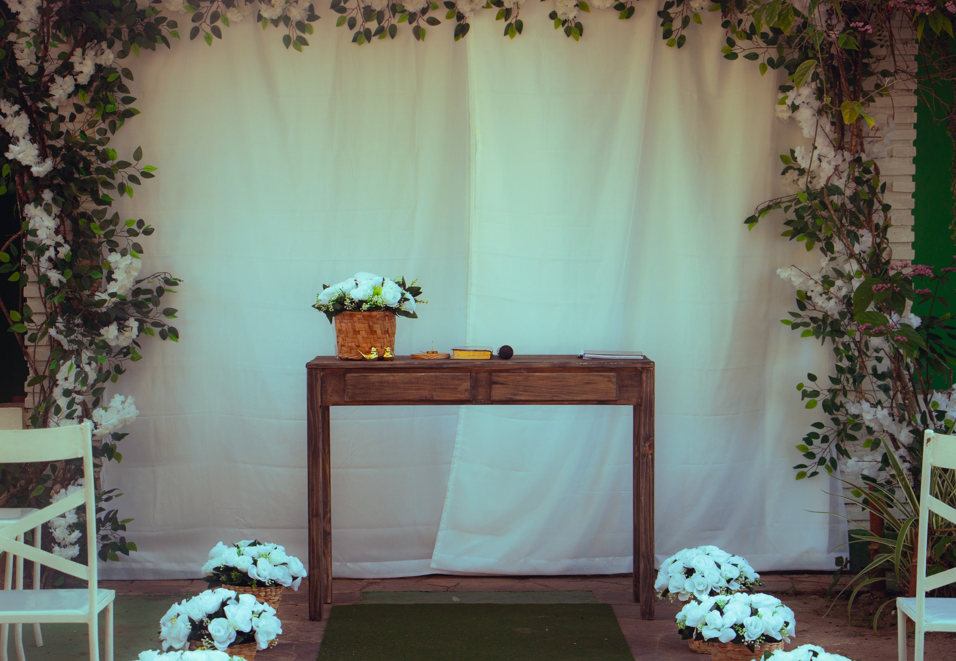 Altar vazio com cortina branca e mesa de madeira, casamento de M & I
