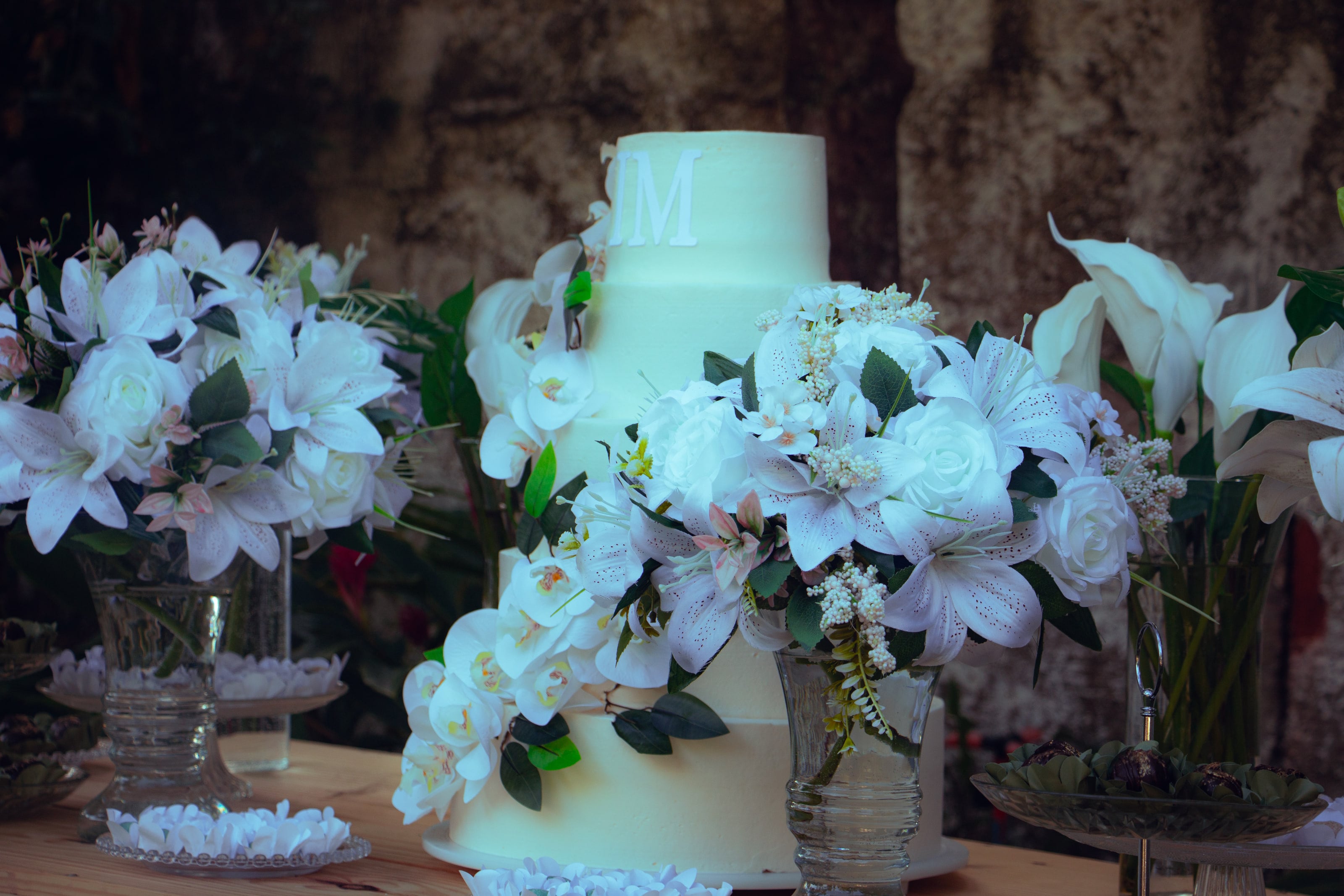 Bolo branco com flores brancas na mesa, casamento de M & I