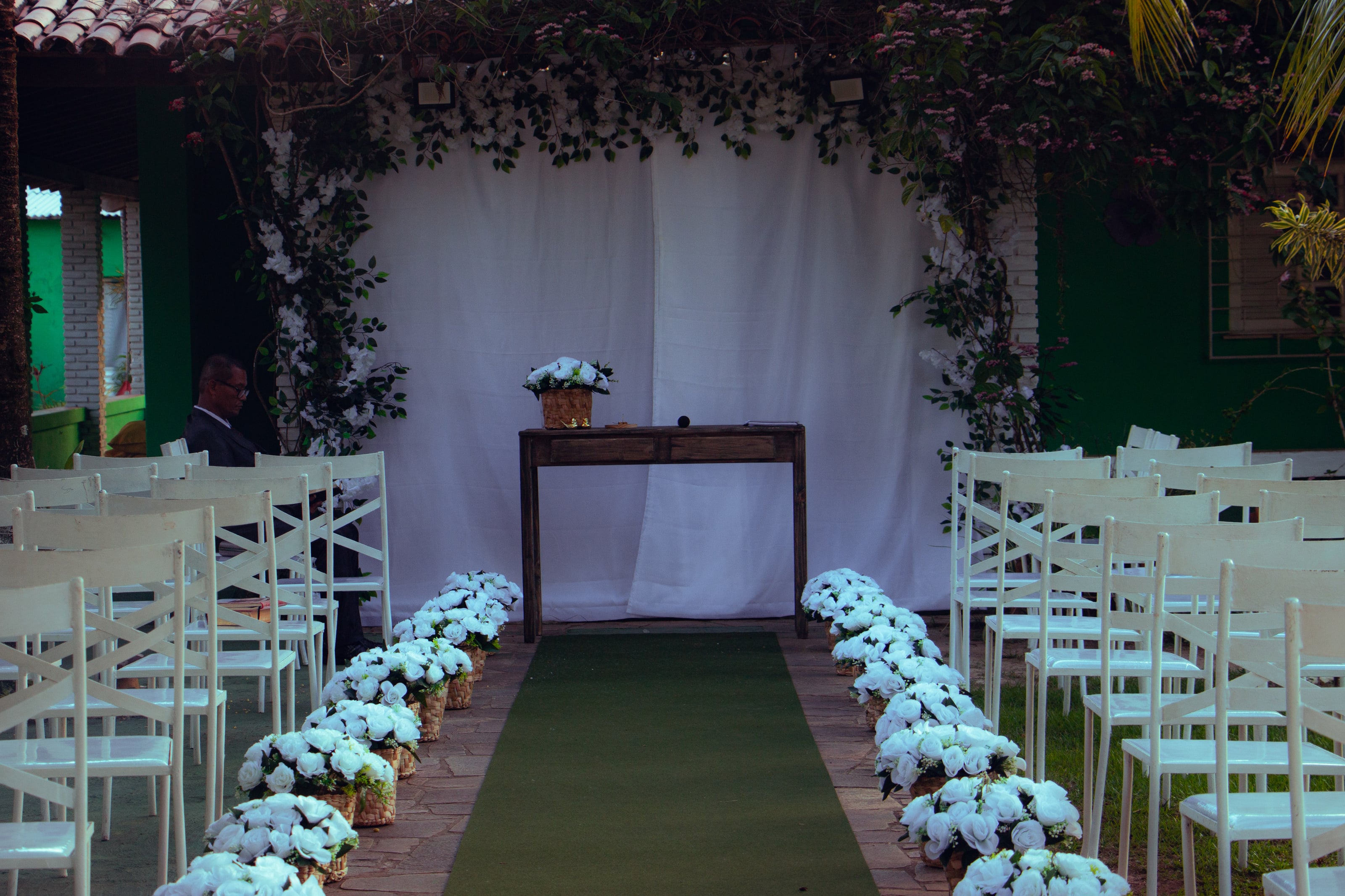 Corredor de cadeiras brancas e flores antes da cerimônia, casamento de M & I
