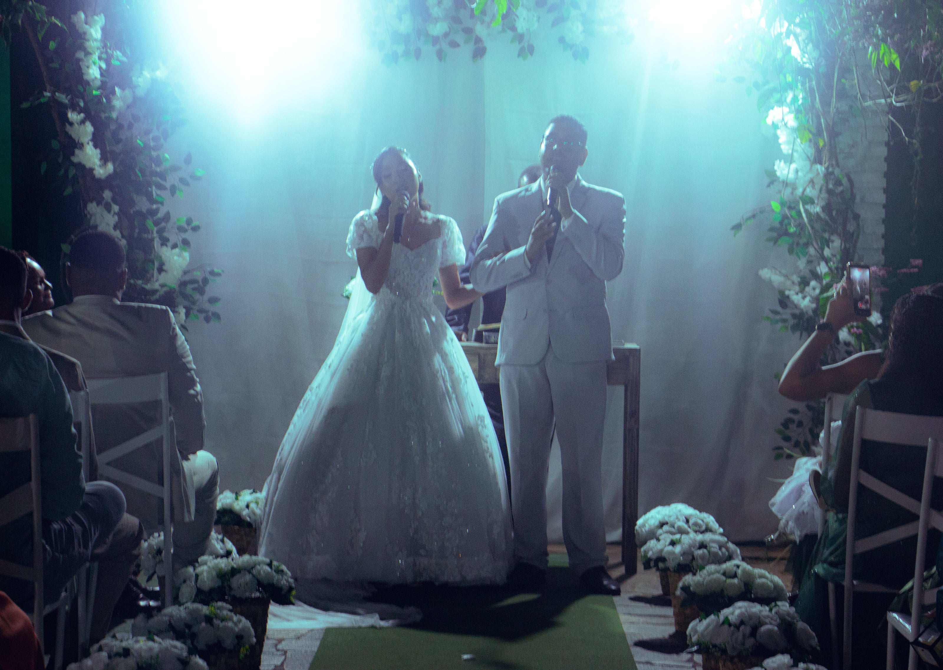 Cerimônia vista do fundo, com o altar iluminado, casamento de M & I