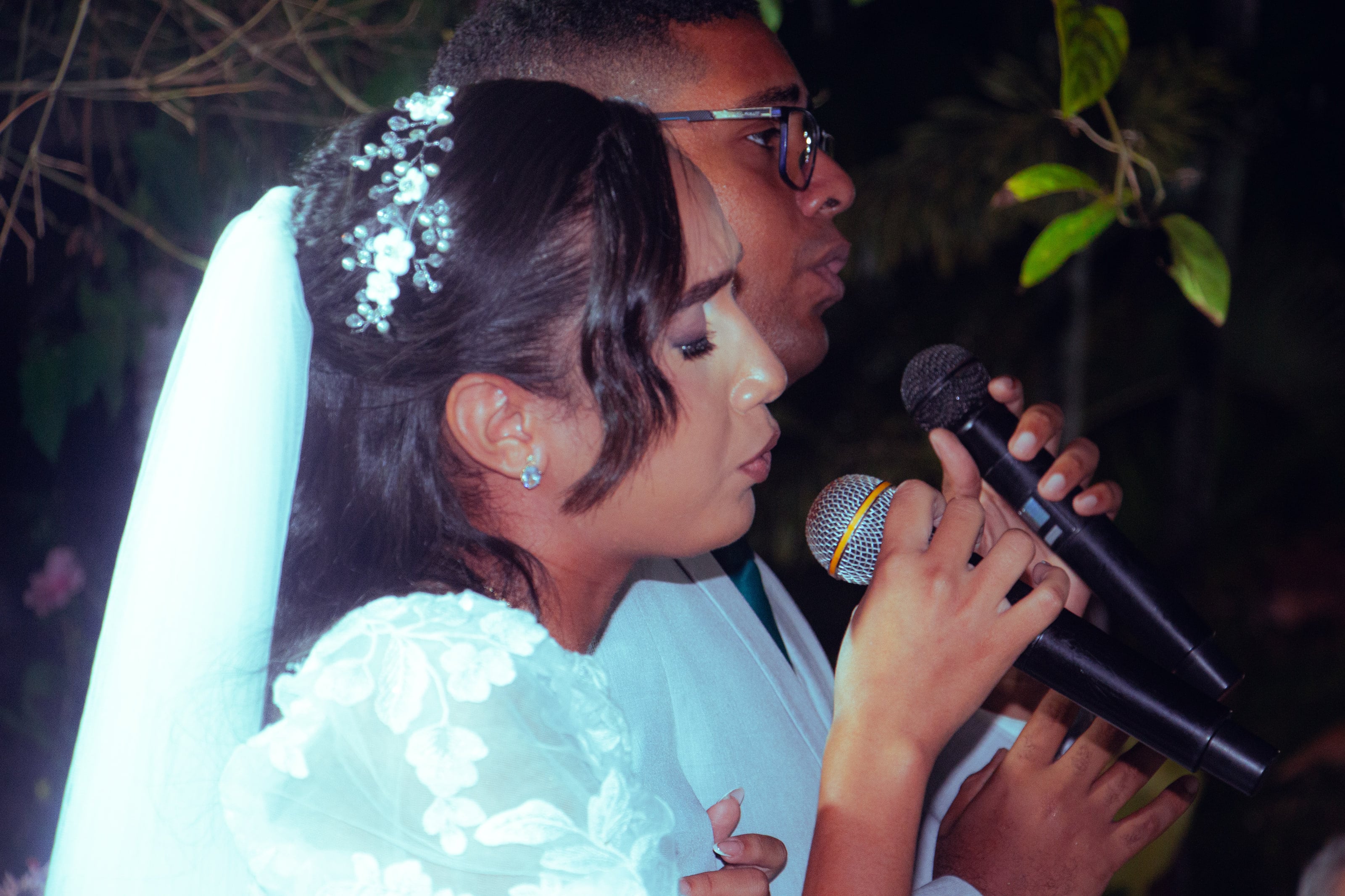 Casal canta ao microfone durante a cerimônia, casamento de M & I