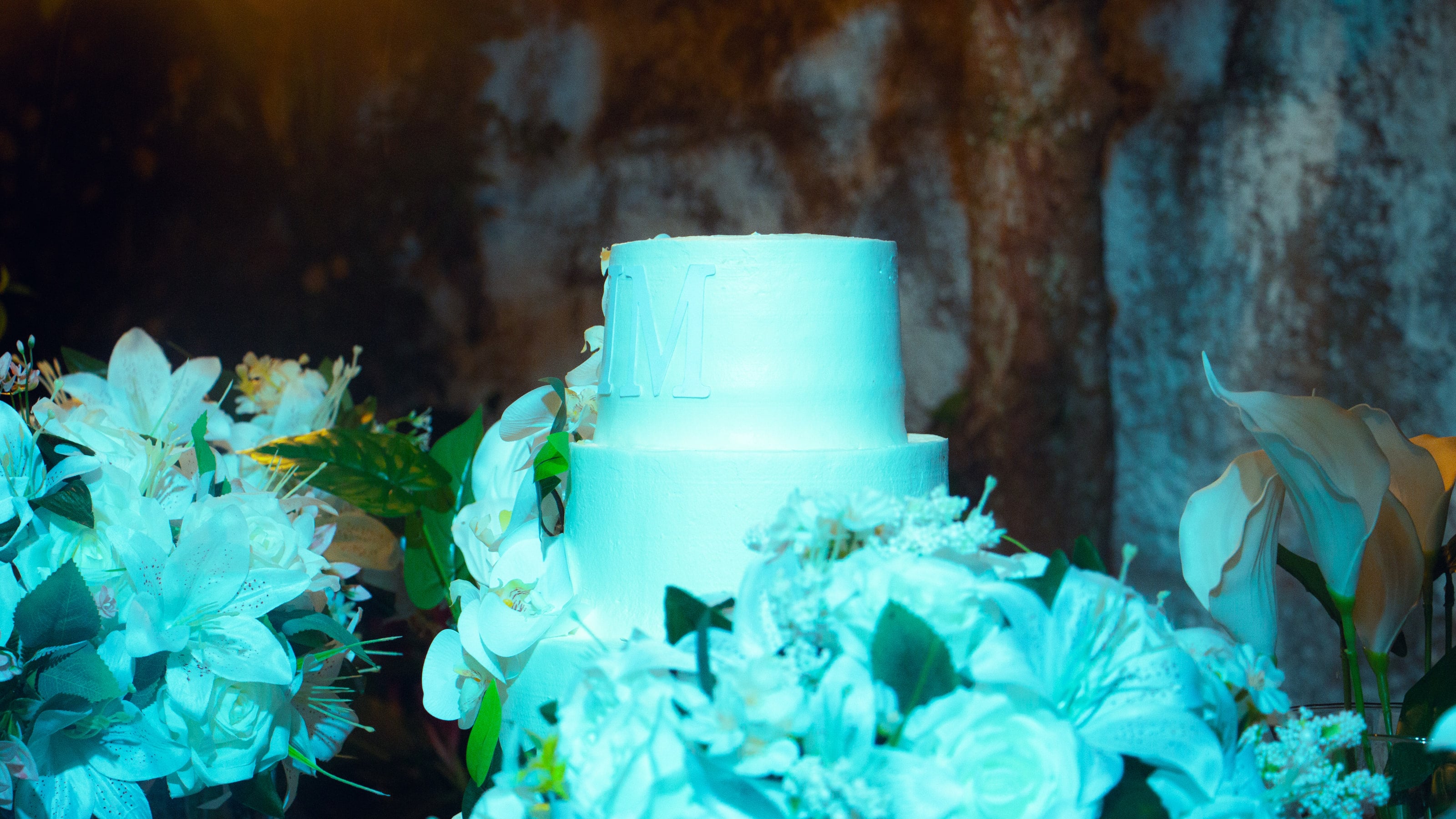 Bolo com orquídeas iluminado à noite, casamento de M & I