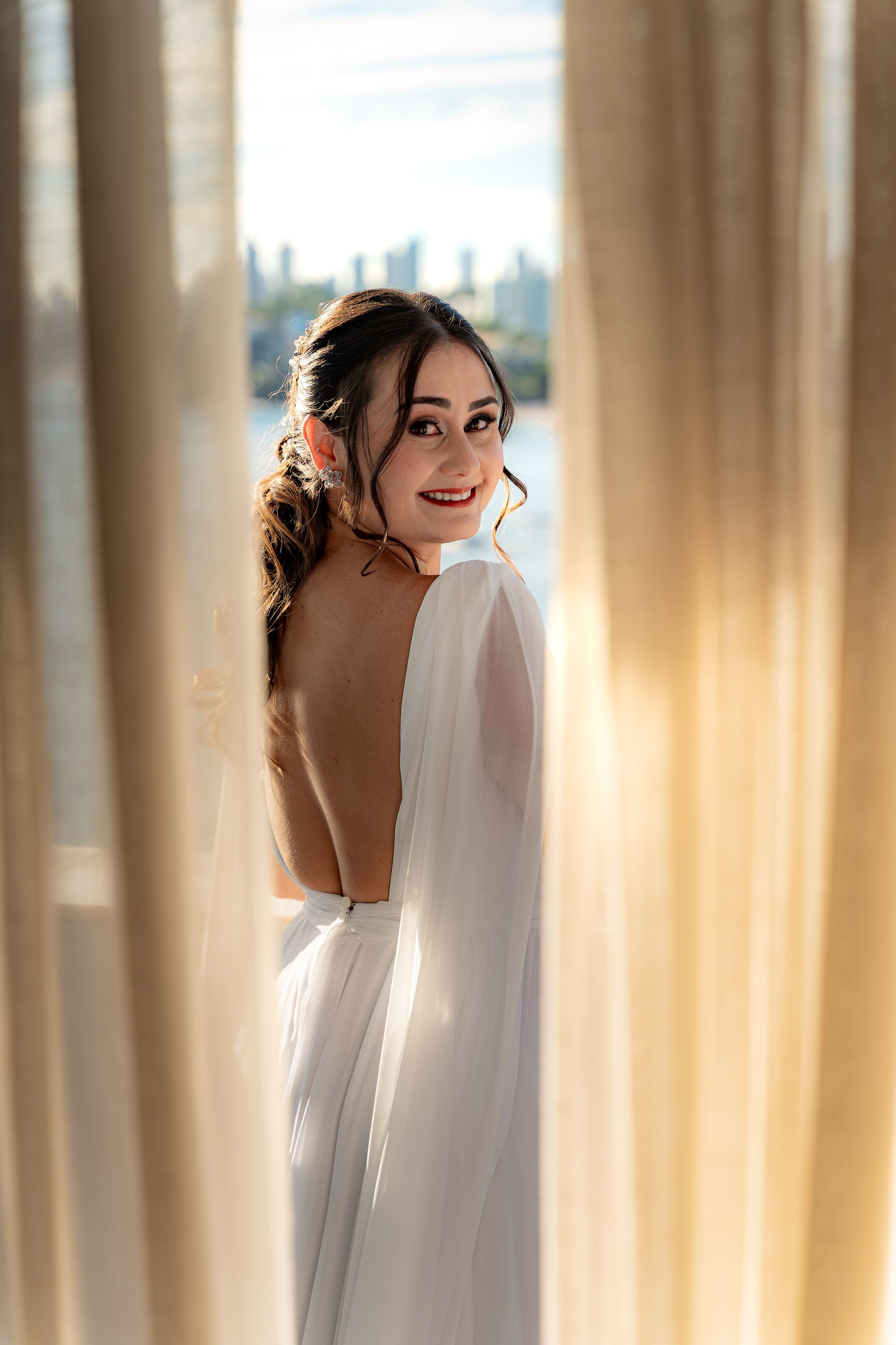 Noiva olha por cima do ombro, vestido de costas abertas, casamento de N & H