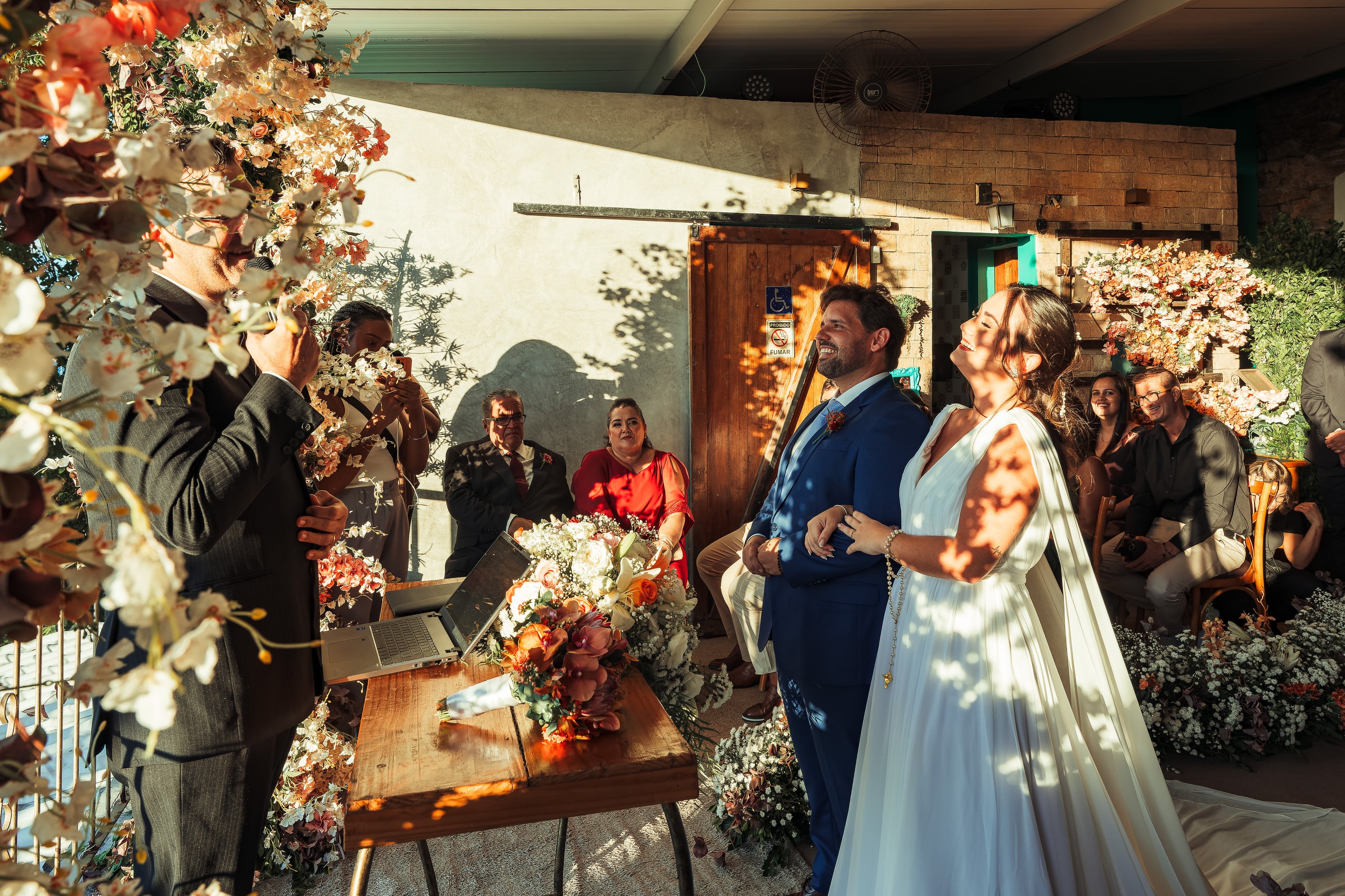 Cerimônia num espaço de pedra com flores laranja, casamento de N & H