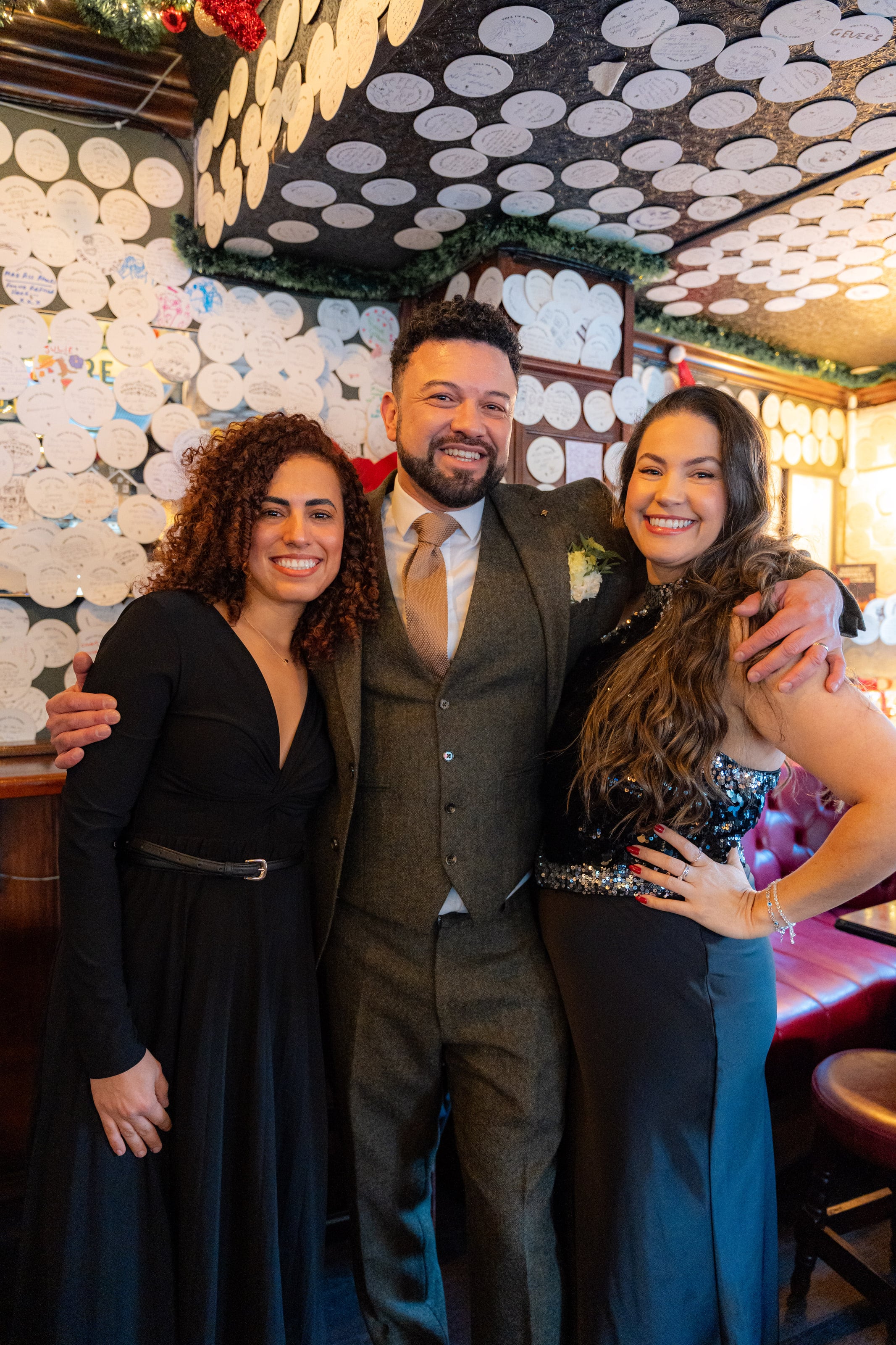 Noivo com duas amigas no pub decorado para o Natal, casamento de W & F