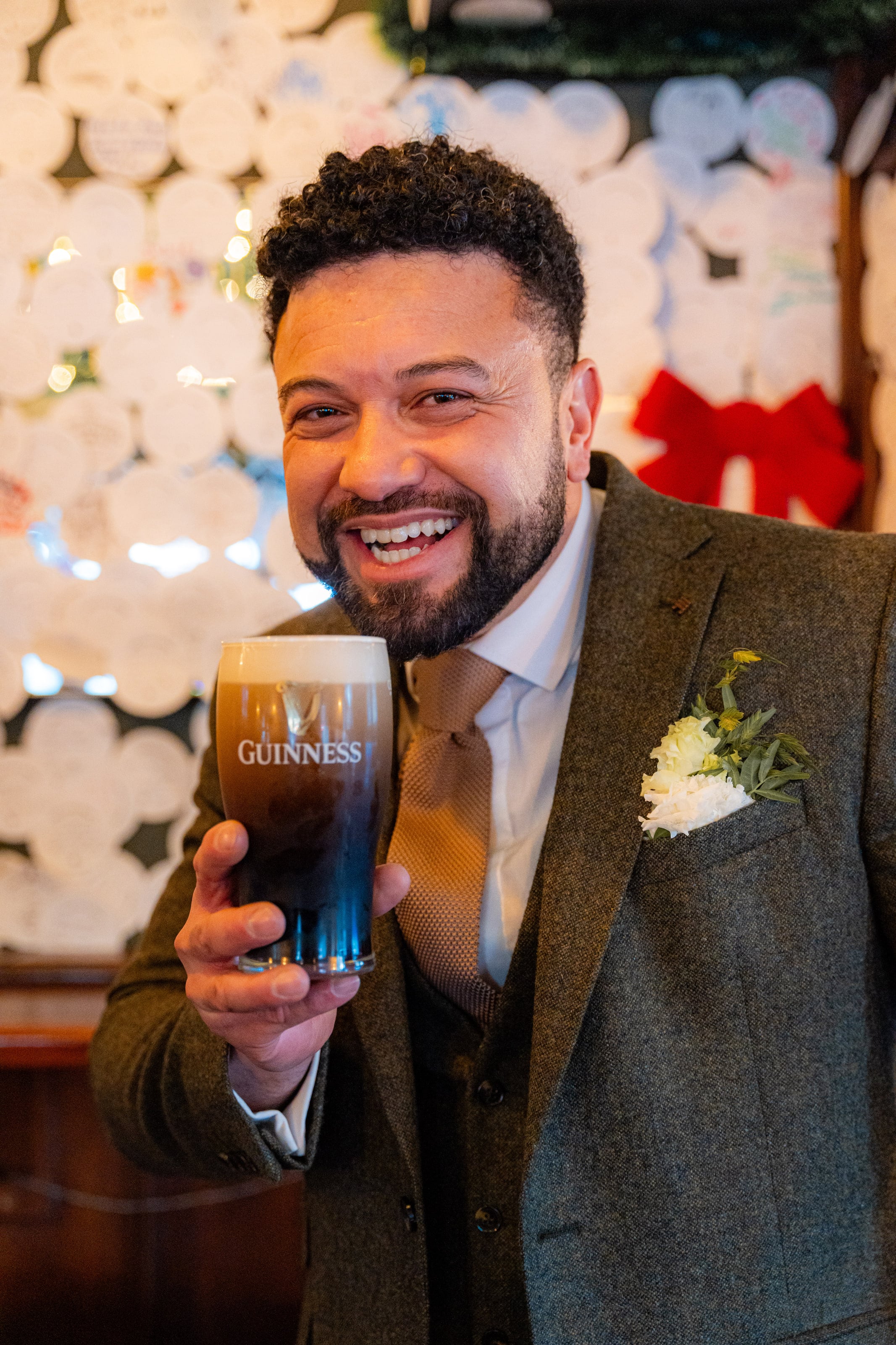 Noivo levanta um copo de cerveja escura, casamento de W & F