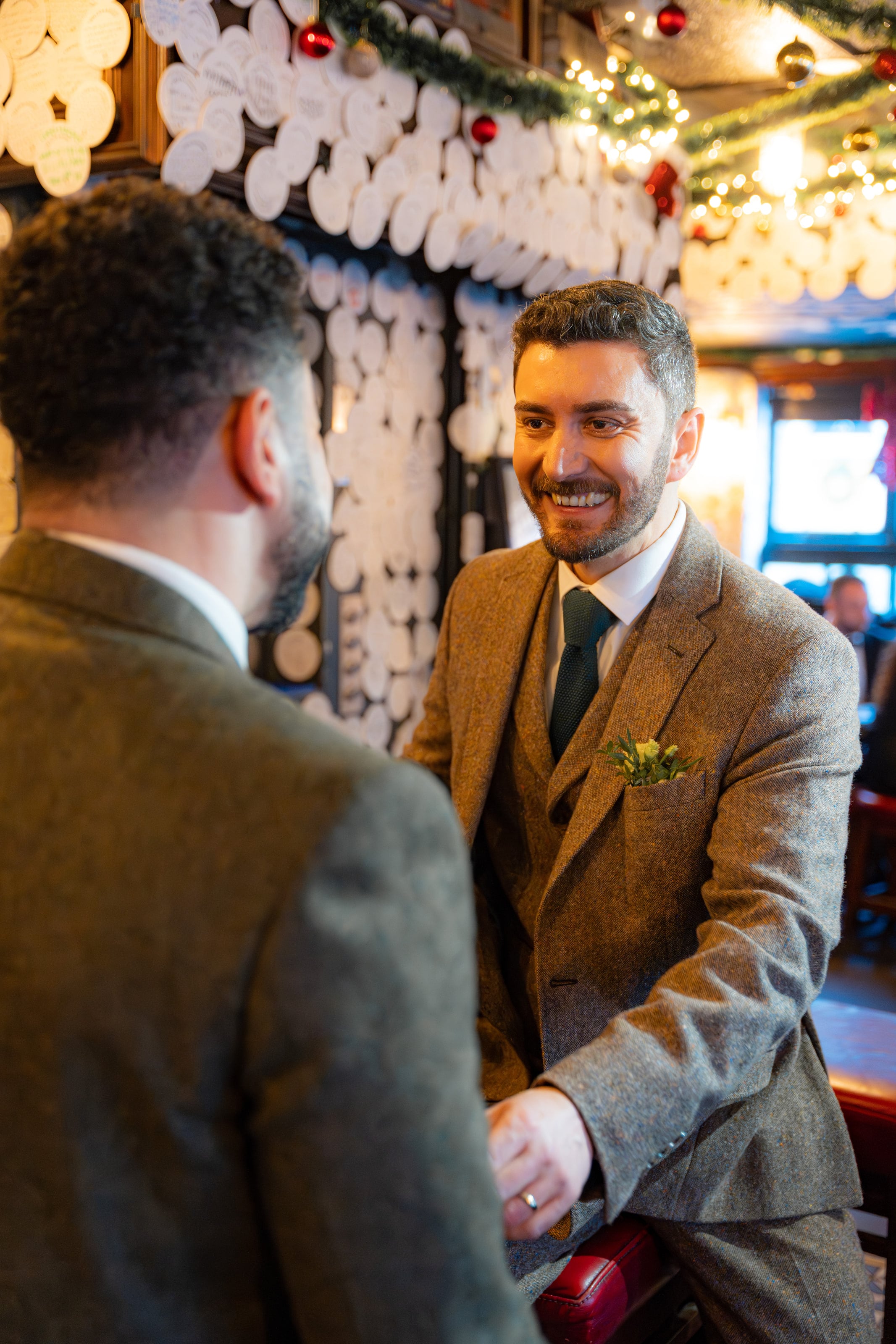 Os noivos sorrindo no balcão do pub, casamento de W & F