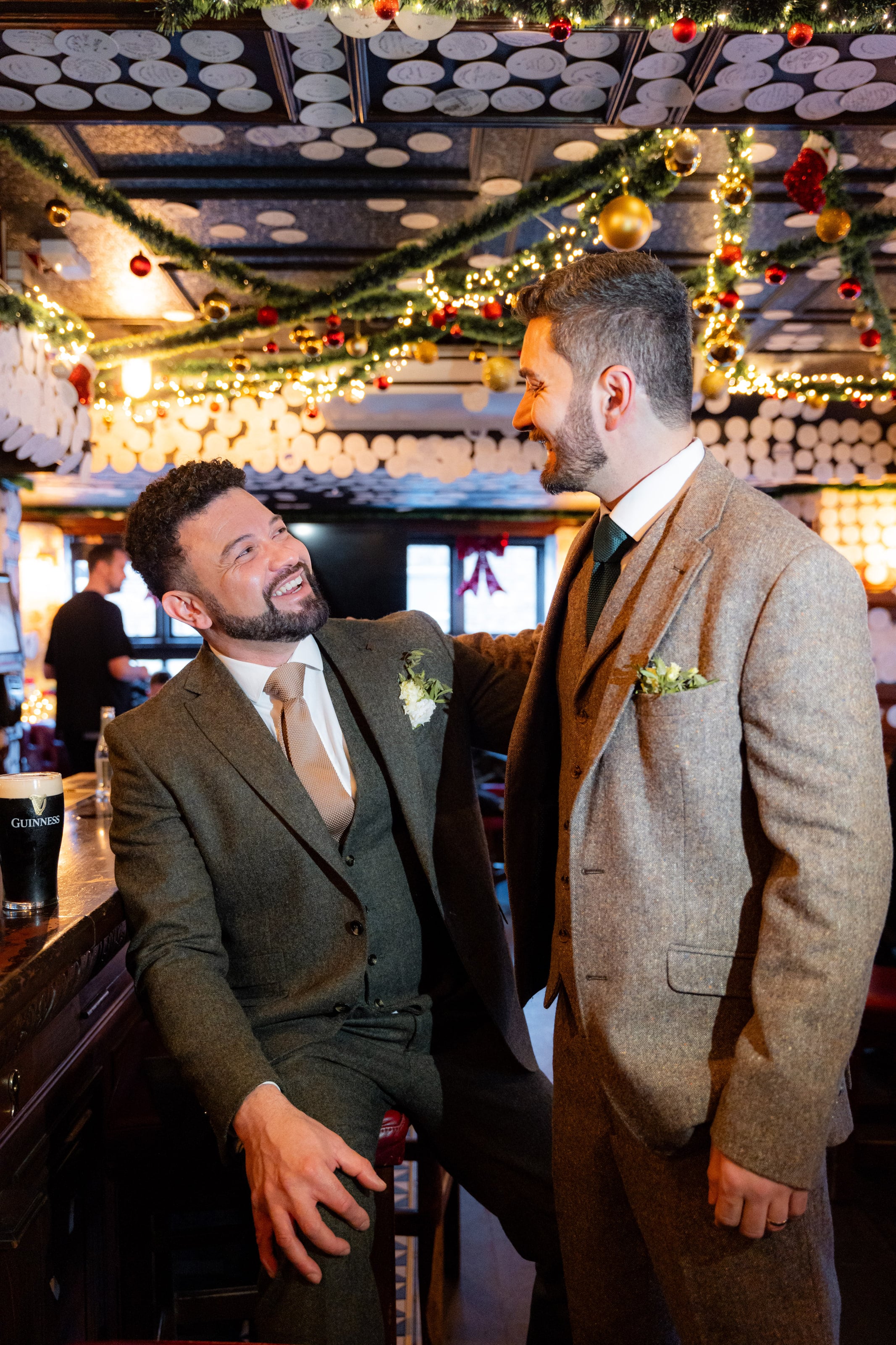 Os noivos abraçados sob as guirlandas de Natal, casamento de W & F