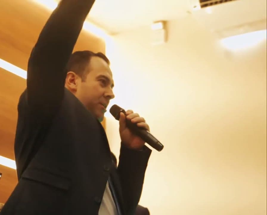 Palestrante falando ao microfone, congresso de jovens filmado pela Duat
