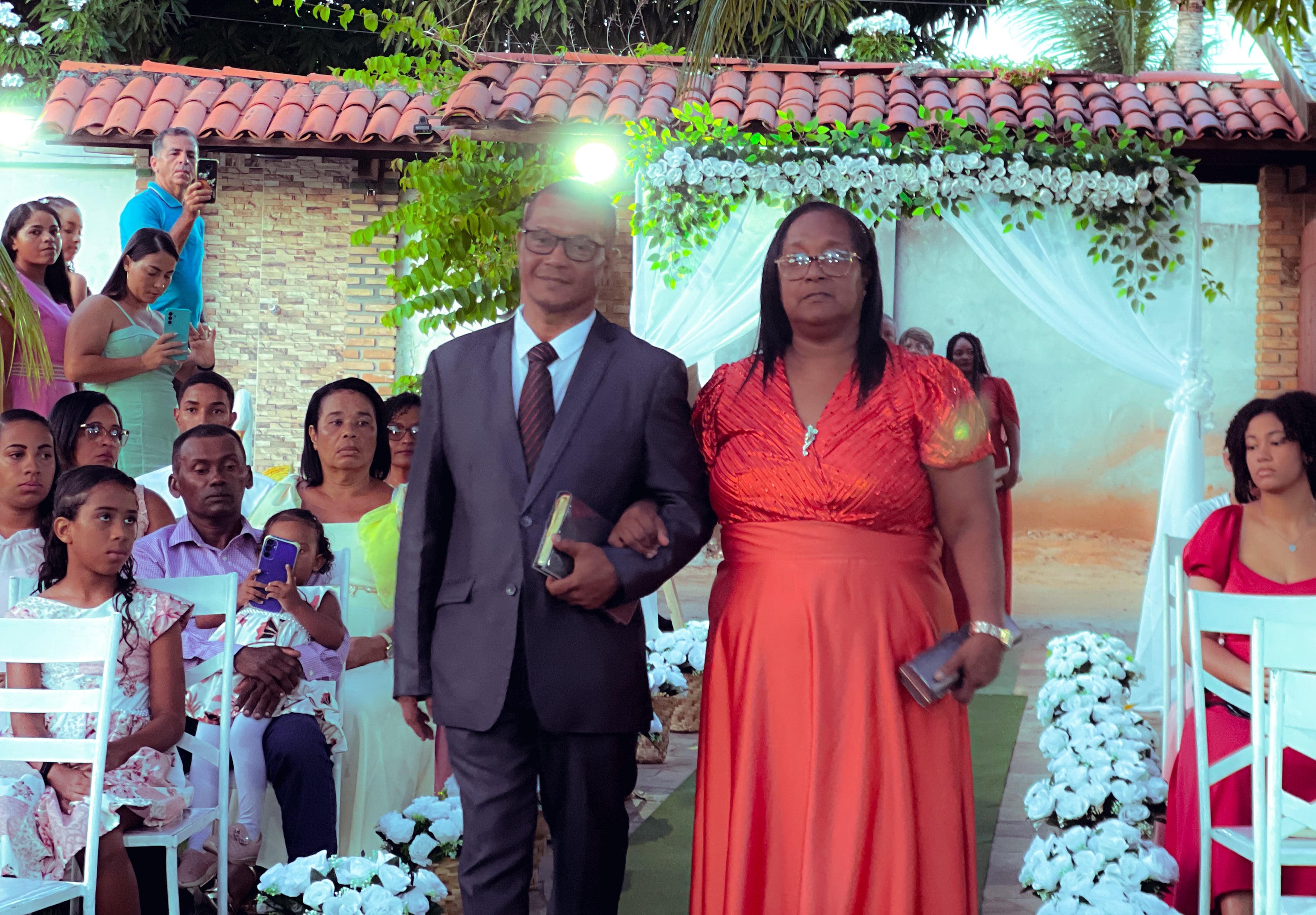 Cortejo de entrada no jardim, entre cadeiras brancas e flores, casamento de M & I